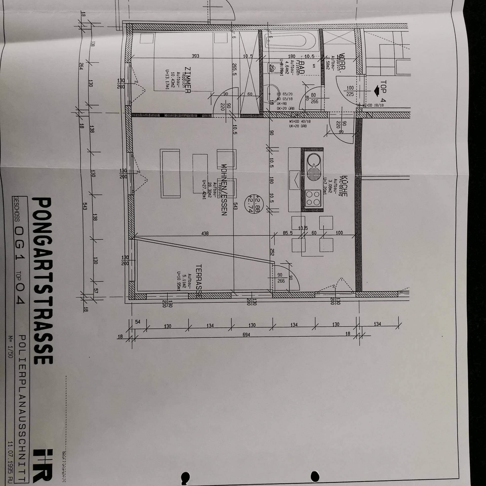 Grundriss einer Wohnung mit offenem Wohn-Essbereich, Küche, Schlafzimmer und Terrasse.