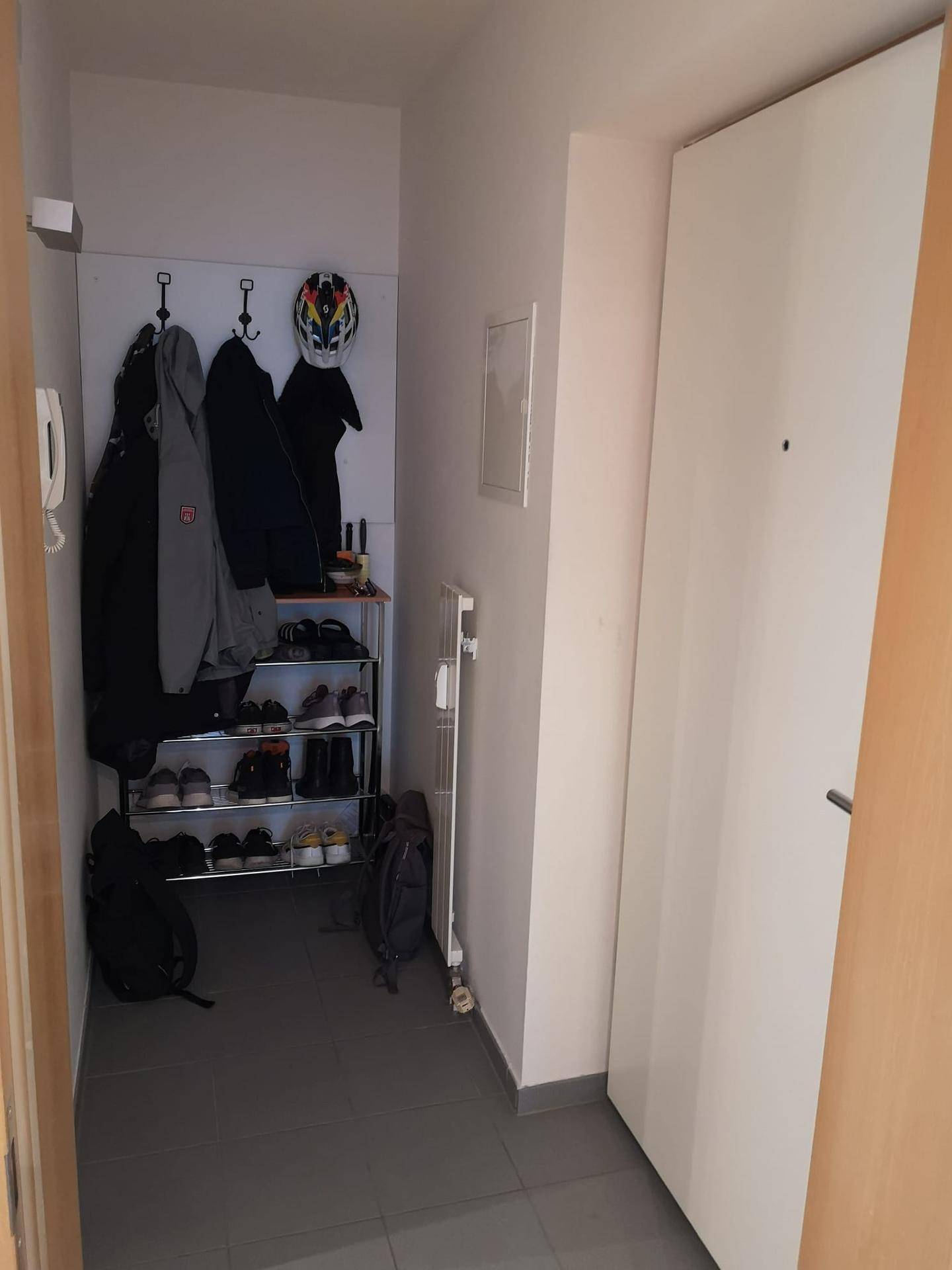 Eingangsbereich mit Garderobe und Schuhregal, ausgestattet mit praktischen Aufbewahrungsmöglichkeiten.