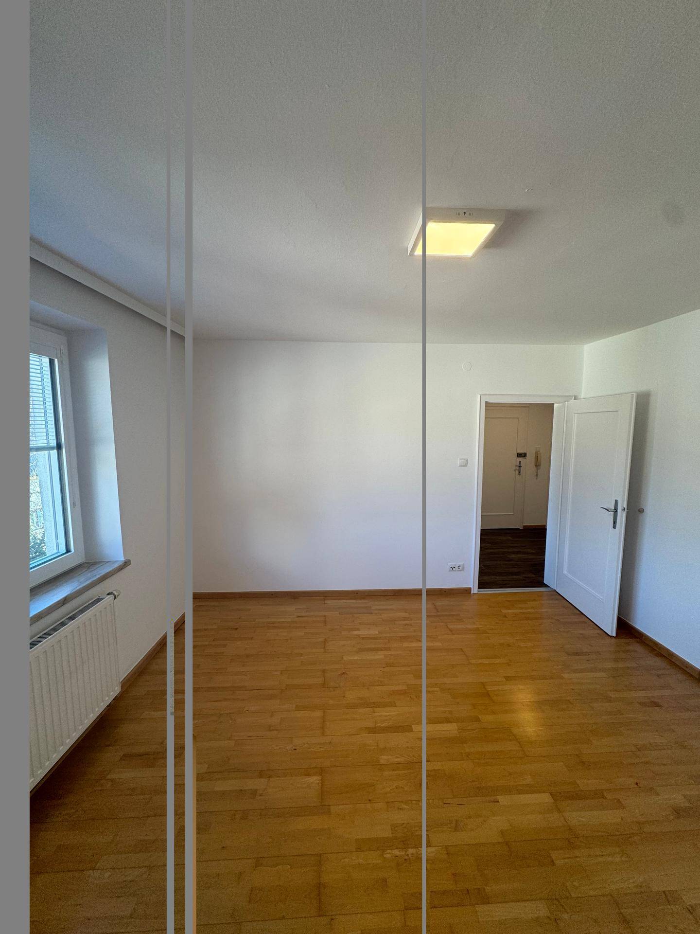 Freundliches Zimmer mit hellem Parkettboden und einem Fenster, das eine angenehme Atmosphäre schafft.