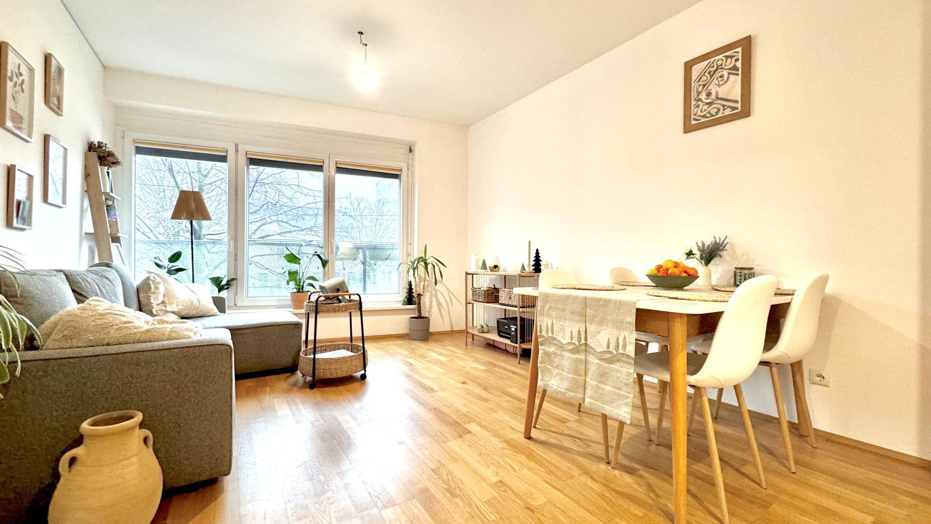 Geräumiger offener Wohn- und Essbereich mit Holzboden, viel Tageslicht und moderner Einrichtung.