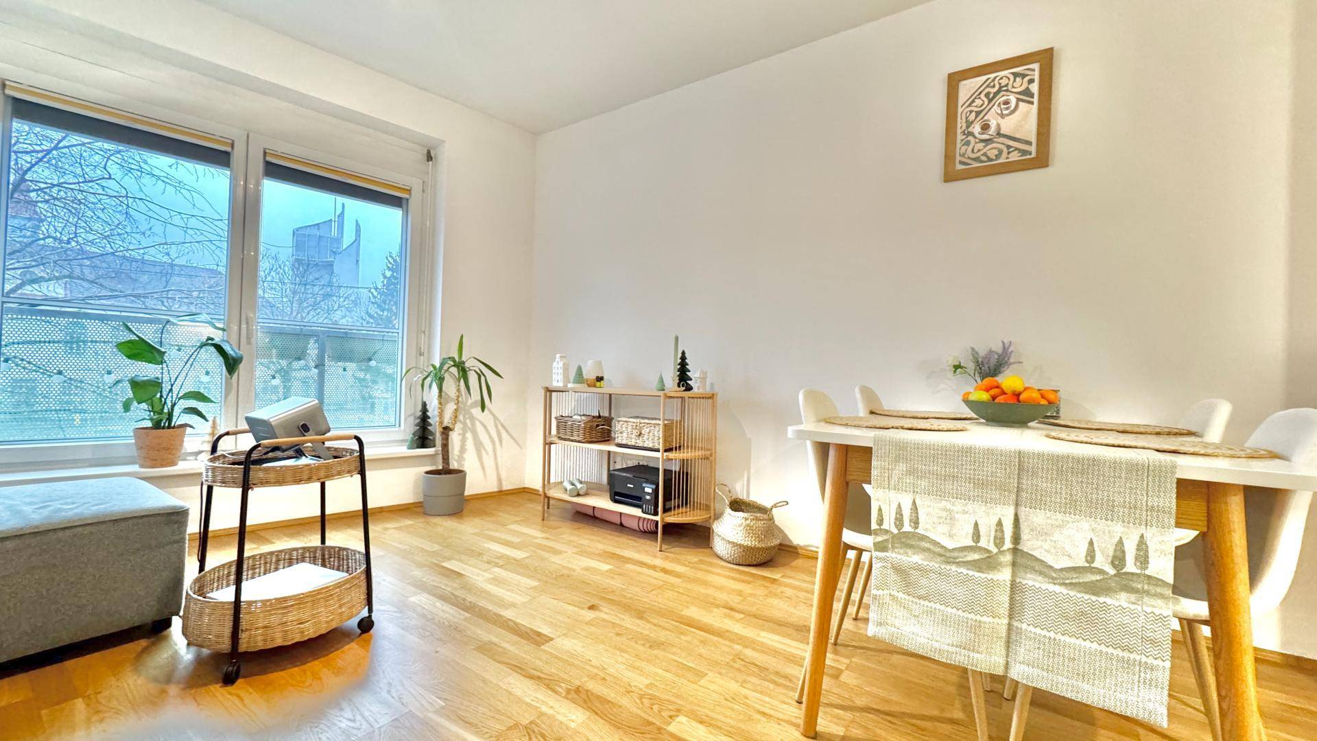 Lichtdurchfluteter Wohn- und Essbereich mit großen Fenstern, Holzboden und stilvoller Dekoration.