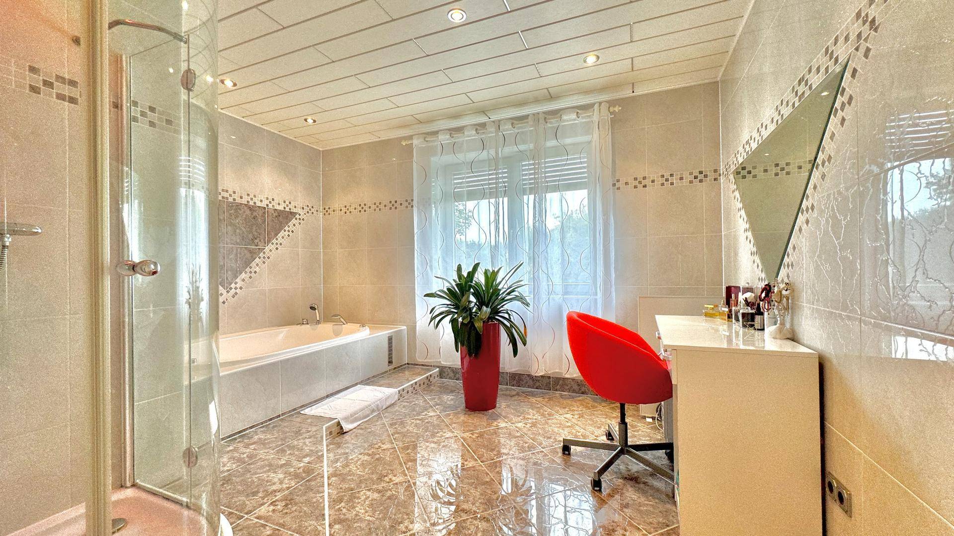 Helles Badezimmer mit Badewanne, Duschkabine und Schminktisch.