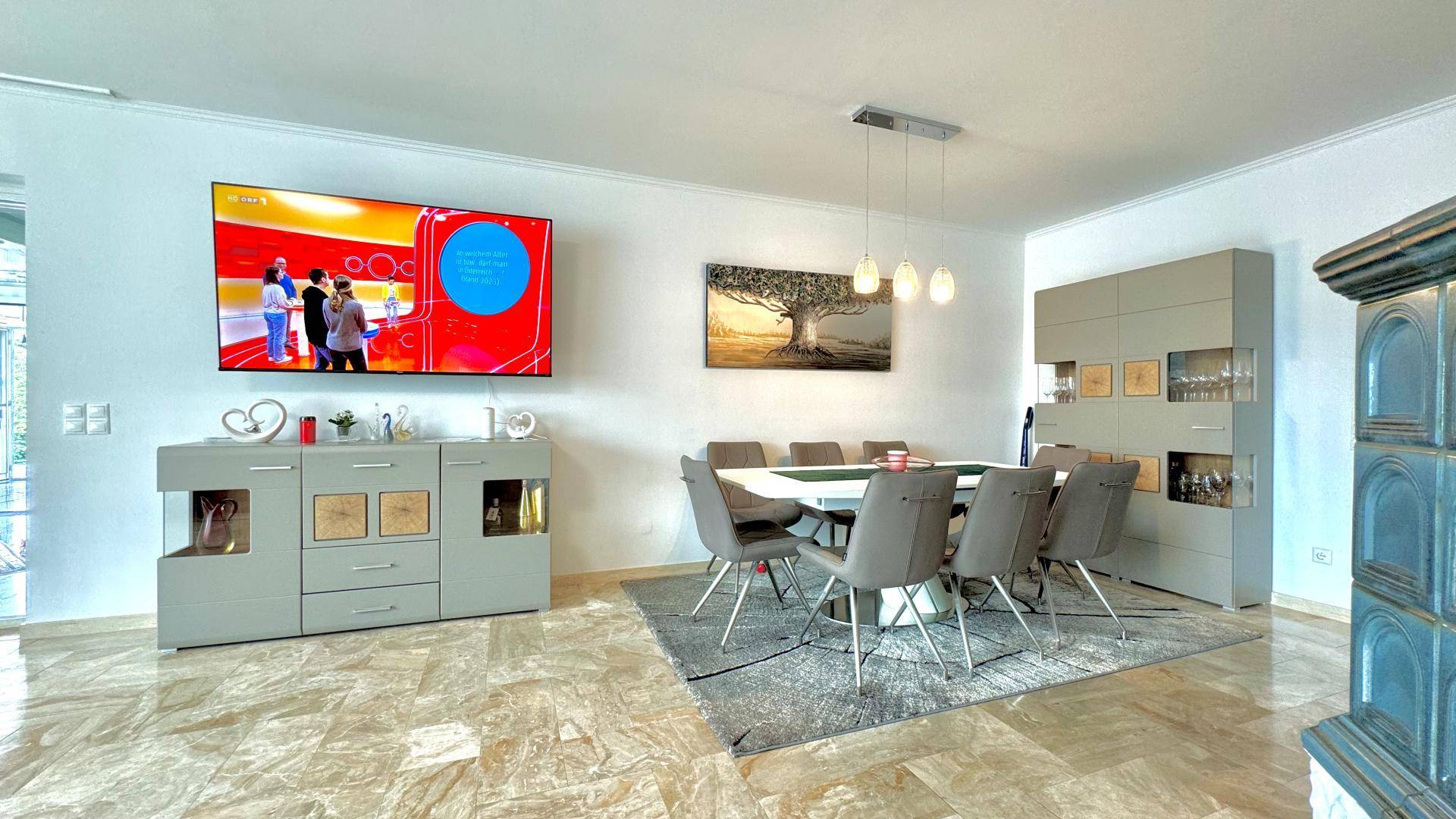 Moderner Essbereich mit großem Esstisch, Stühlen und Sideboard, angrenzend an den Wohnbereich.