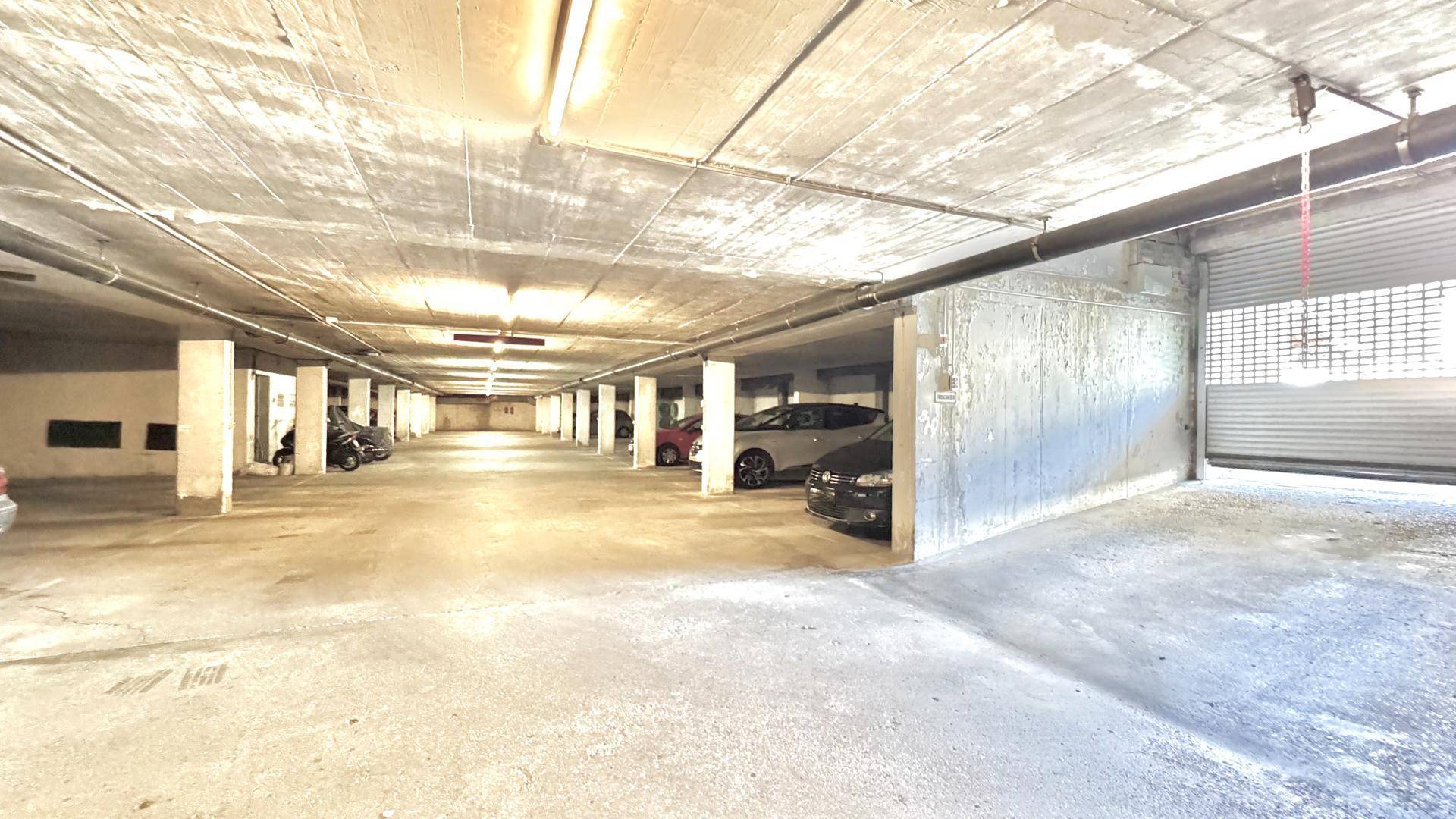 Geräumige Tiefgarage mit mehreren Stellplätzen und Betonwänden.
