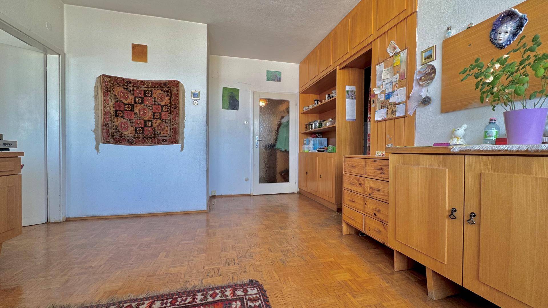 Heller Eingangsbereich, der in den Wohnbereich übergeht, mit praktischen Holz-Einbauschränken.