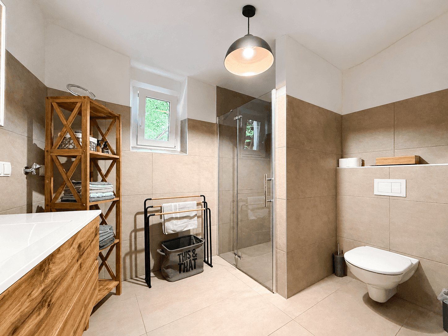 Modernes Badezimmer mit begehbarer Dusche, Wand-WC und beigefarbenen Fliesen.