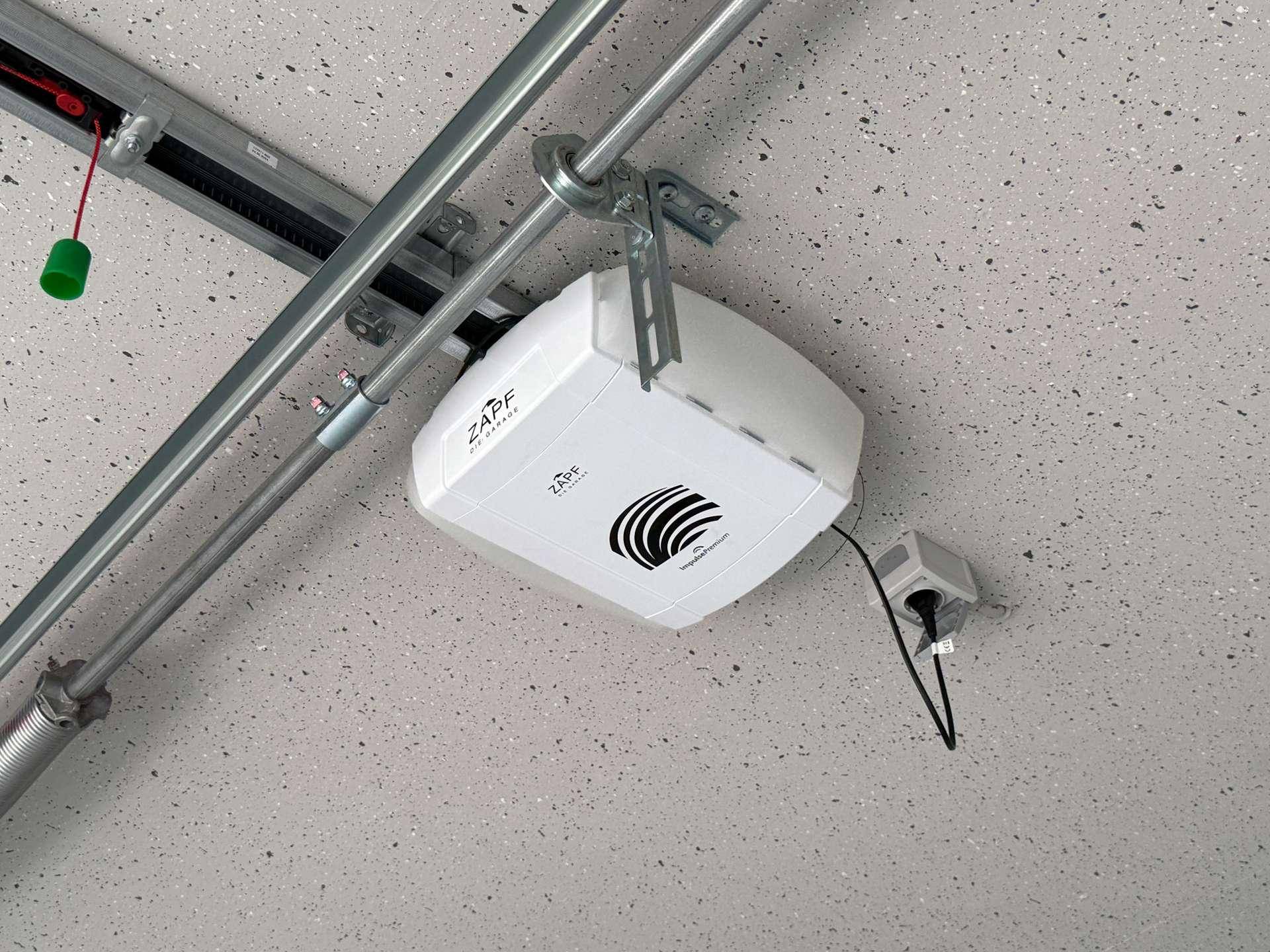 Detailaufnahme des elektrischen Garagentoröffners an der Decke einer modernen und sauberen Garage.