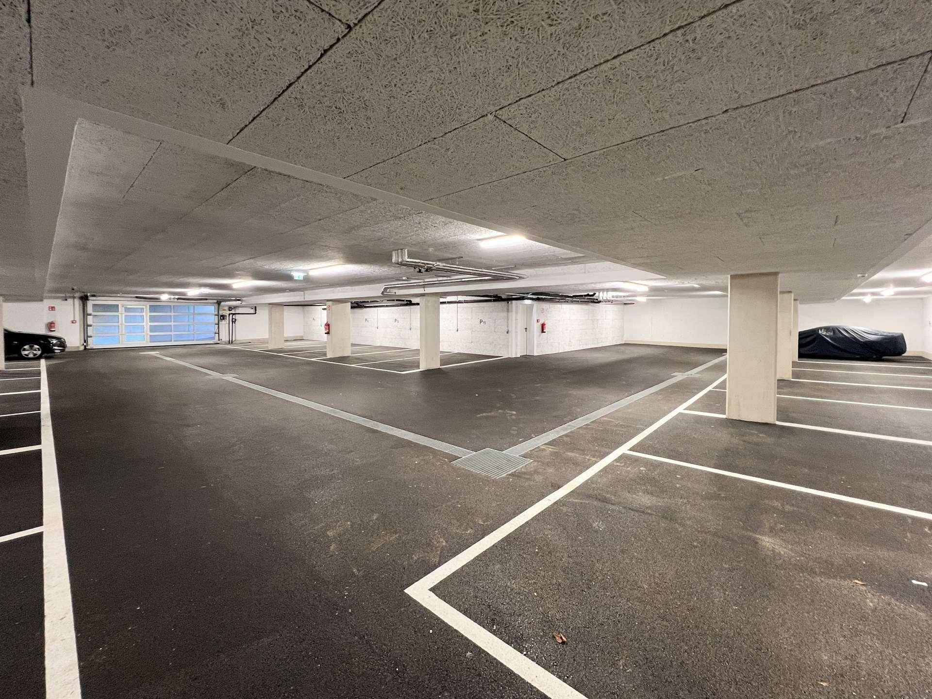 Geräumige Tiefgarage mit vielen Stellplätzen und guter Beleuchtung.