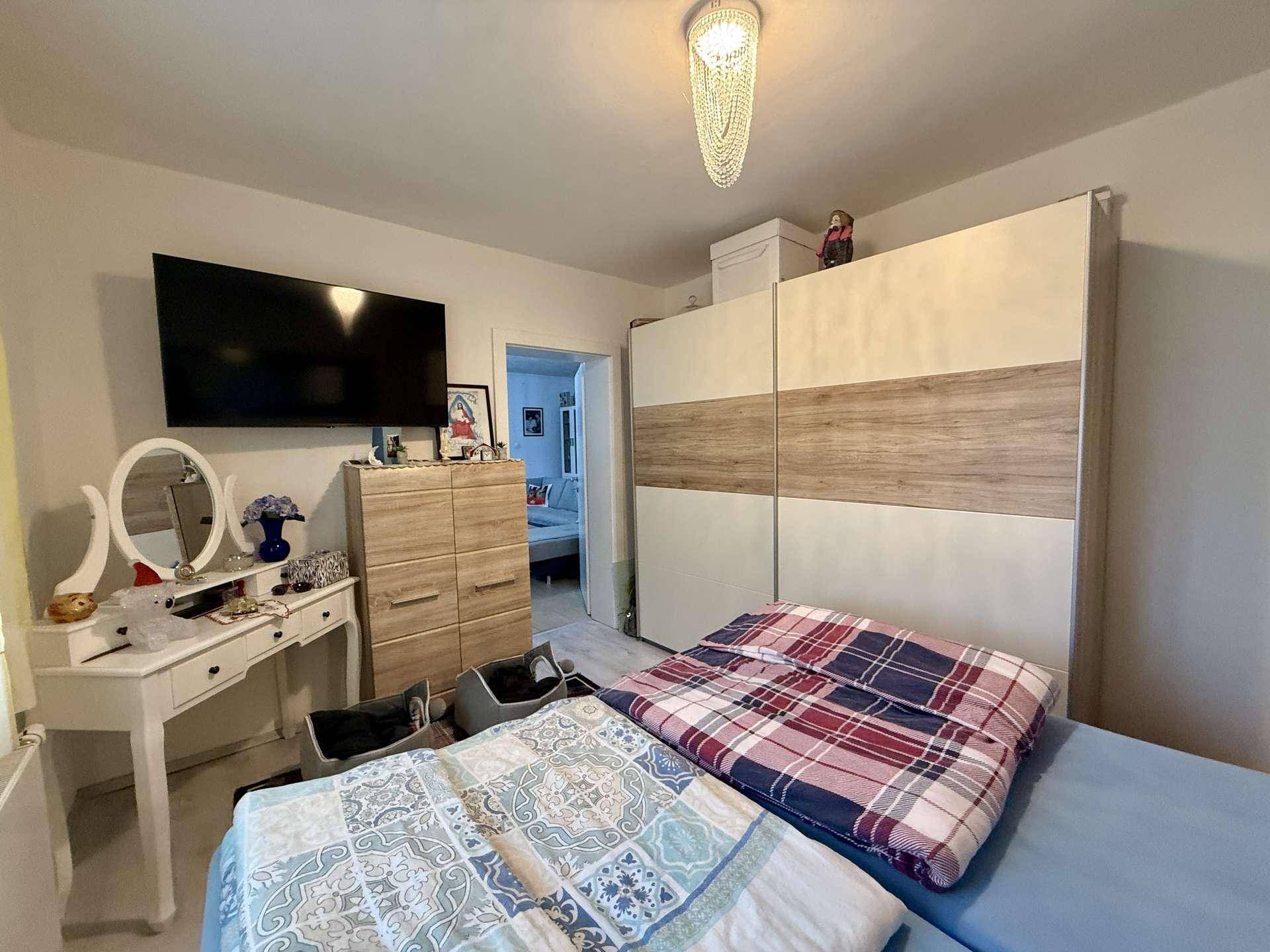 Schlafzimmer mit Doppelbett, großem Kleiderschrank und Schminktisch.
