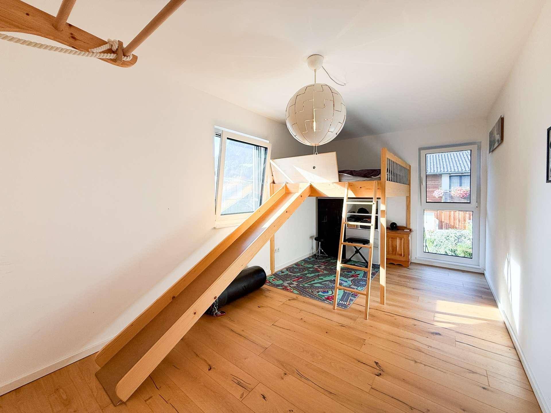 Kinderzimmer mit Hochbett, Rutsche und Holzboden, ideal zum Spielen.