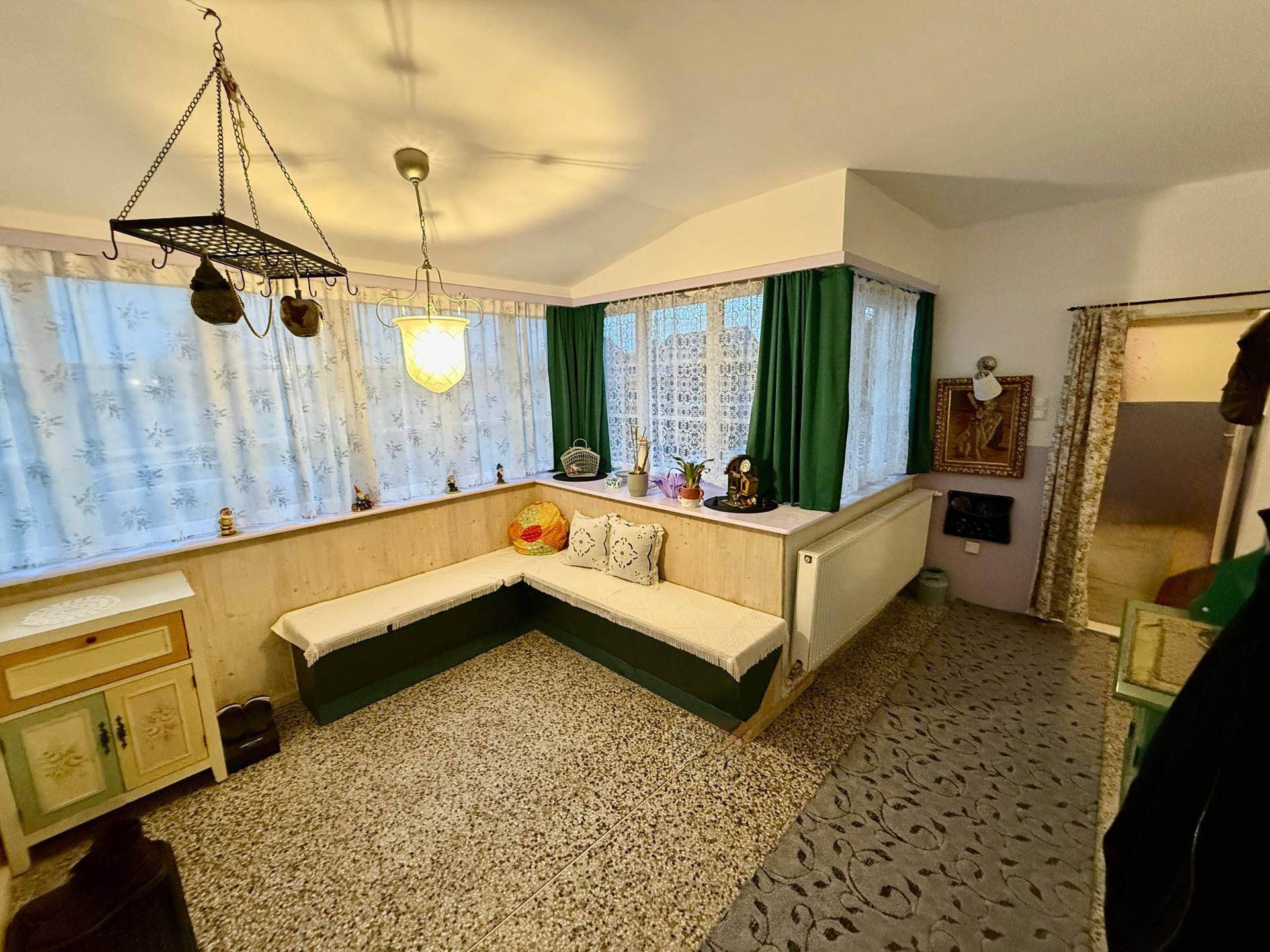 Gemütlicher Eckbereich mit eingebauter Sitzbank, Fenstern und gemustertem Boden.