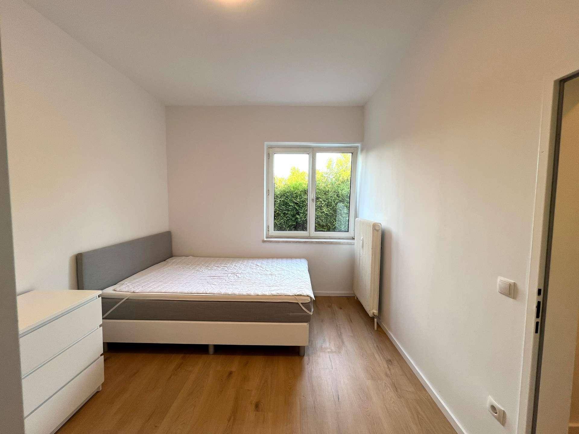 Geräumiges Schlafzimmer mit komfortablem Bett, Kommode und Fenster für viel Tageslicht.