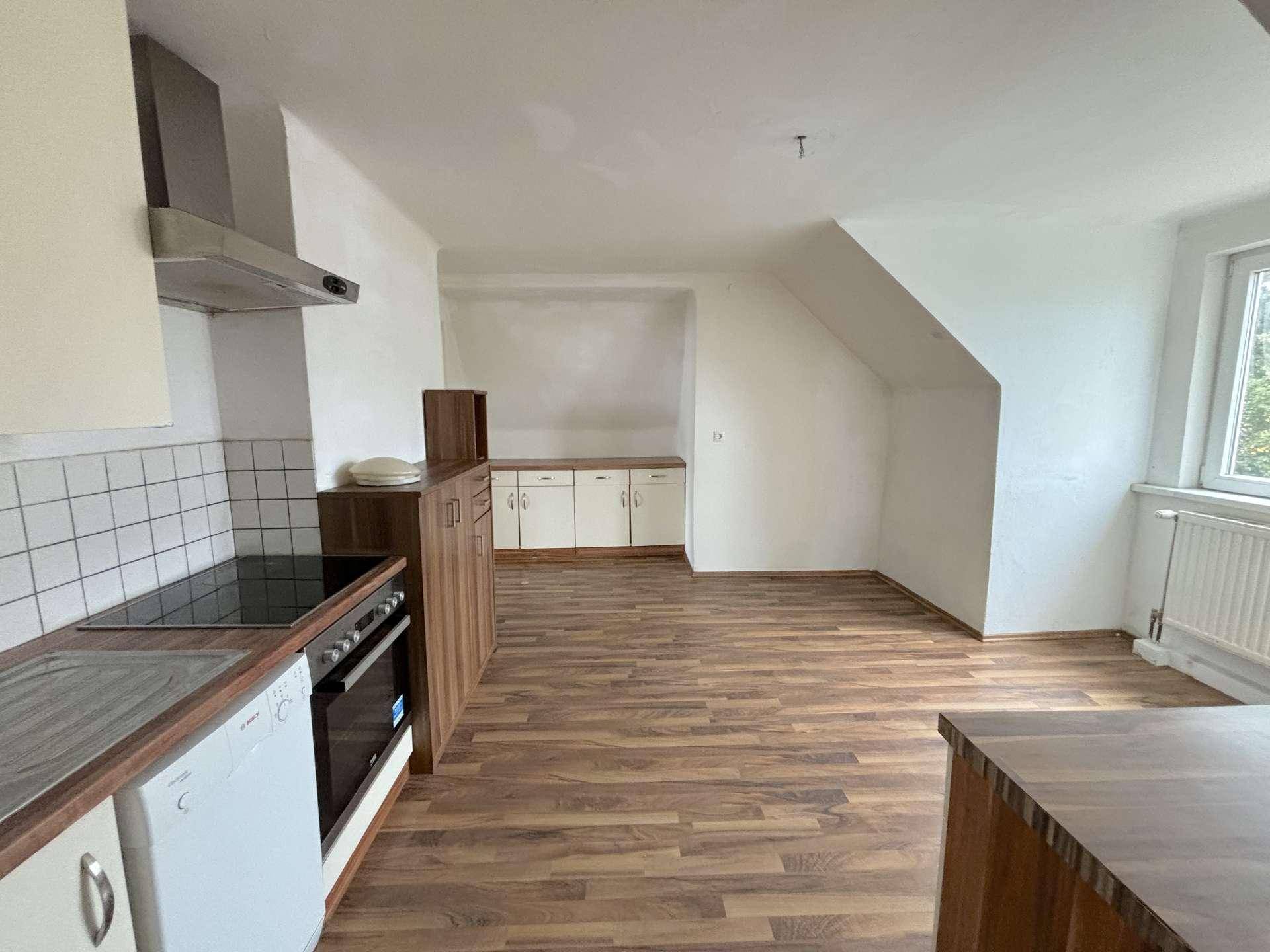 Küche mit Dachschräge und Fenster, bietet Platz für weitere Küchenmöbel.