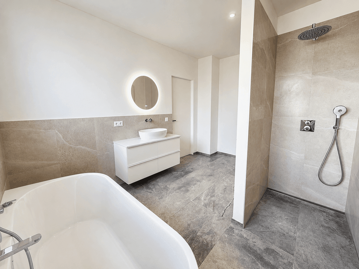 Luxuriöses Badezimmer mit freistehender Badewanne, ebenerdiger Dusche und Doppelwaschbecken.