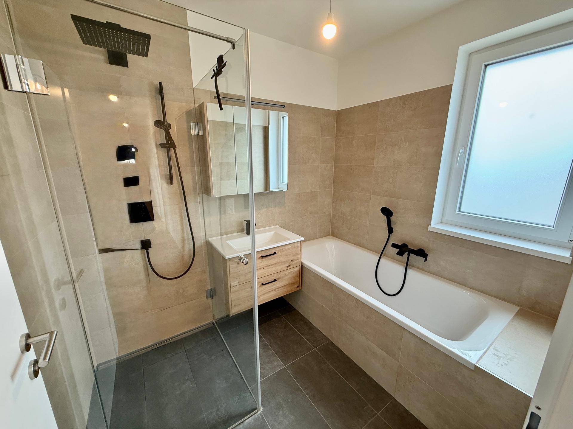Modernes Badezimmer mit begehbarer Dusche, Badewanne, Holzwaschtisch und Fenster.