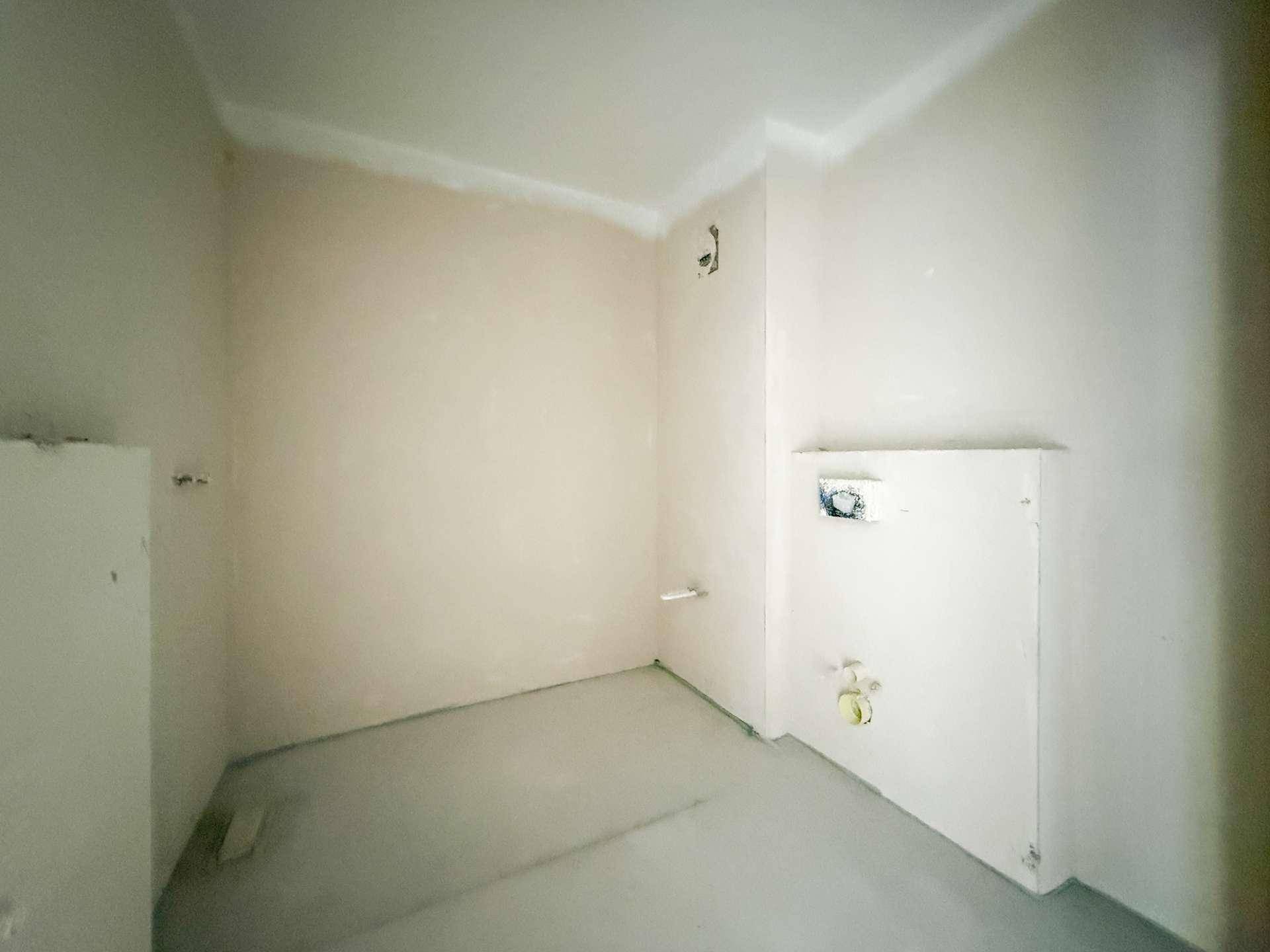 Kleiner Raum im Rohbau mit Anschlüssen für ein WC oder Badezimmer.
