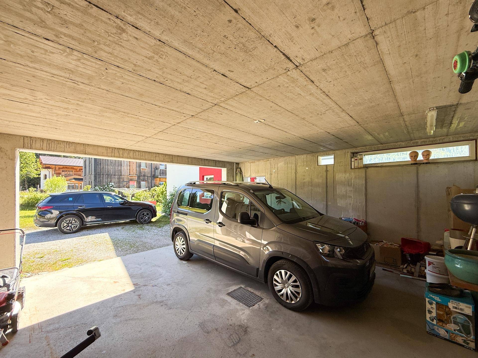 Überdachter Parkplatz mit Betonboden und -decke, bietet Platz für zwei Fahrzeuge.