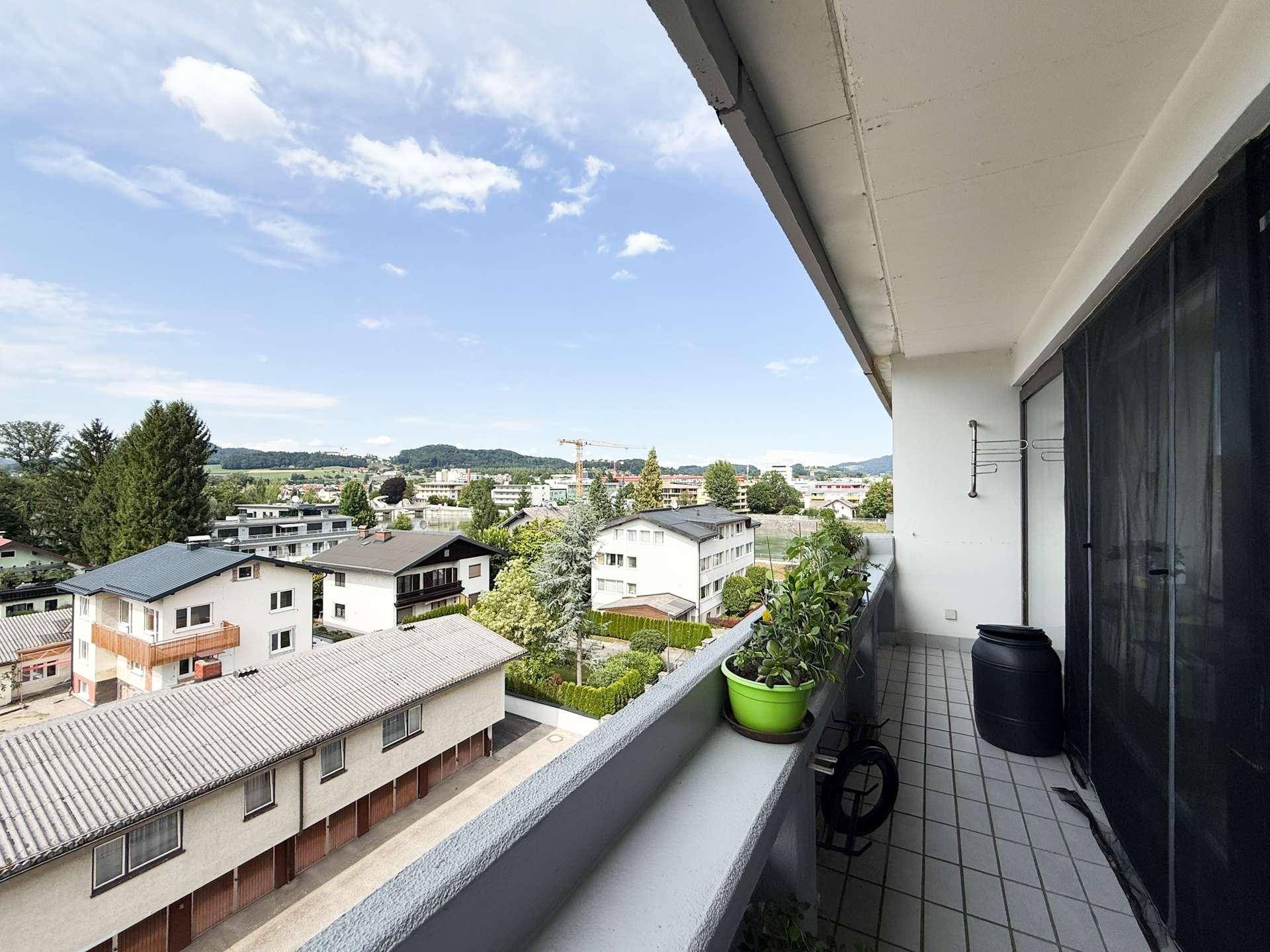 Geräumiger Balkon mit Fliesenboden und weitem Blick über die Umgebung und Berge.