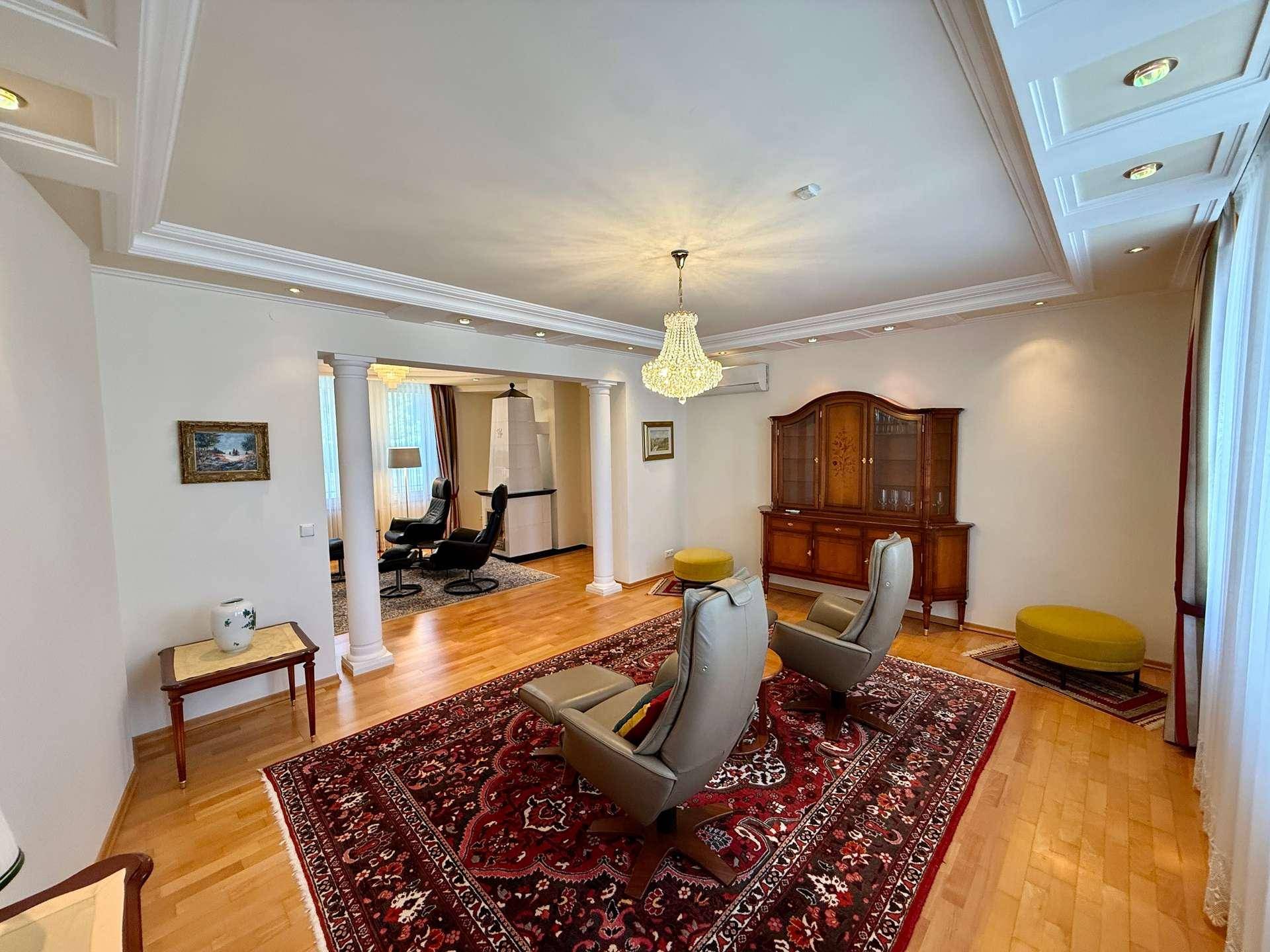Elegantes Wohnzimmer mit Parkettboden, Kronleuchter und klassischen Möbeln.