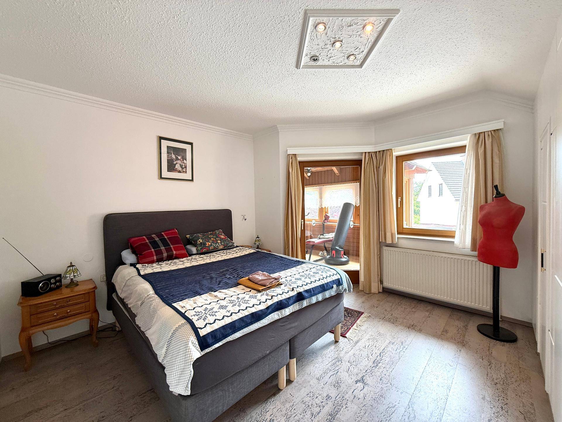 Gemütliches Schlafzimmer im Dachgeschoss mit Doppelbett, Fenster und Holzboden.