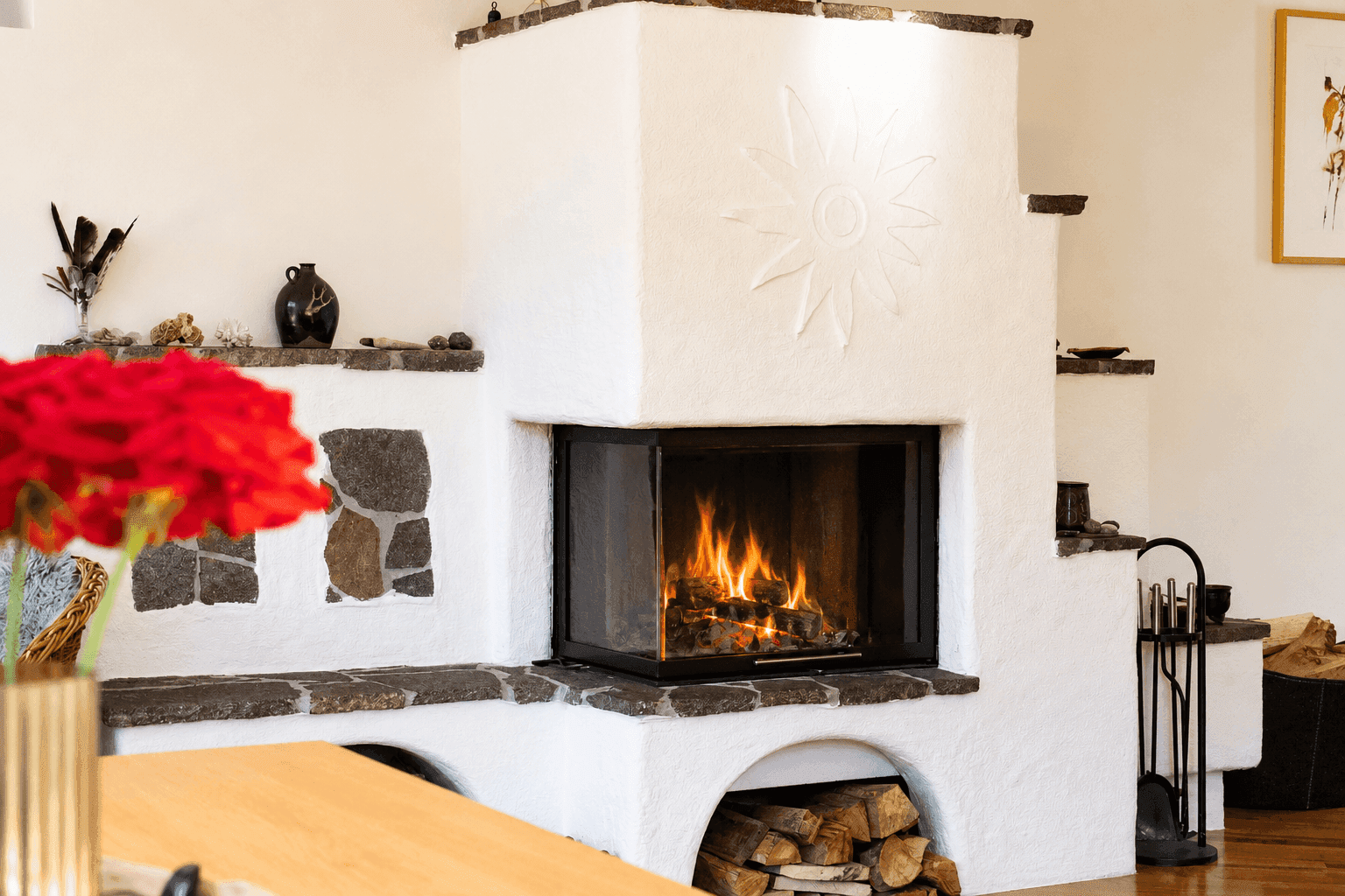 Gemütlicher Kamin mit Steinverkleidung und Holzablage, einladend für kalte Abende.
