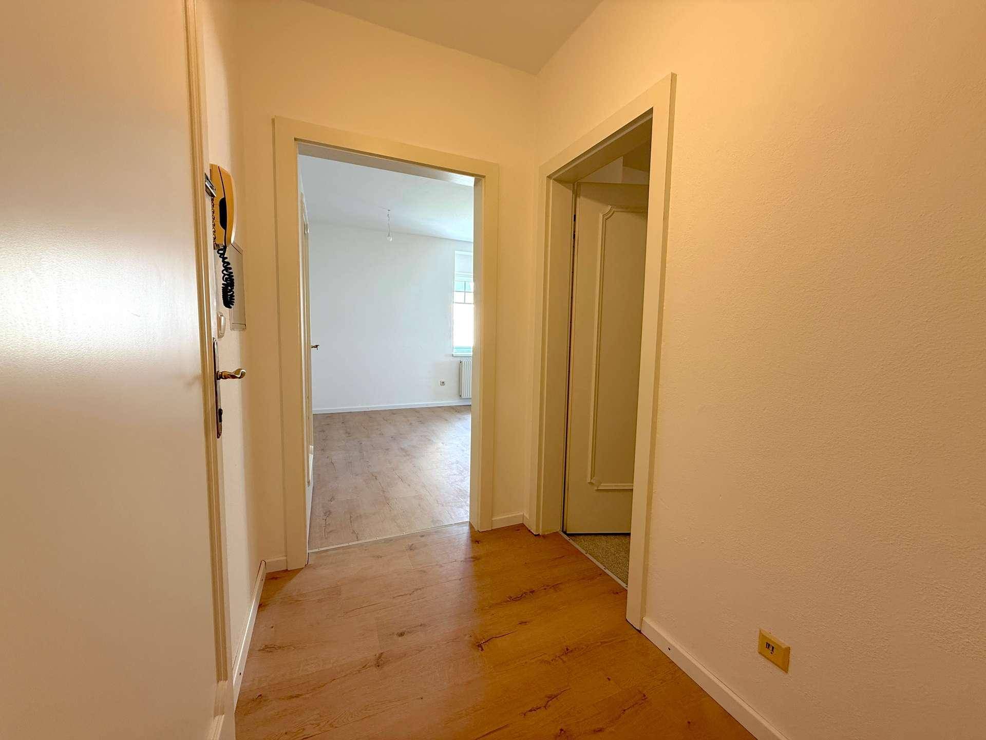Heller Flur mit Laminatboden und Zugang zu verschiedenen Zimmern der Wohnung.