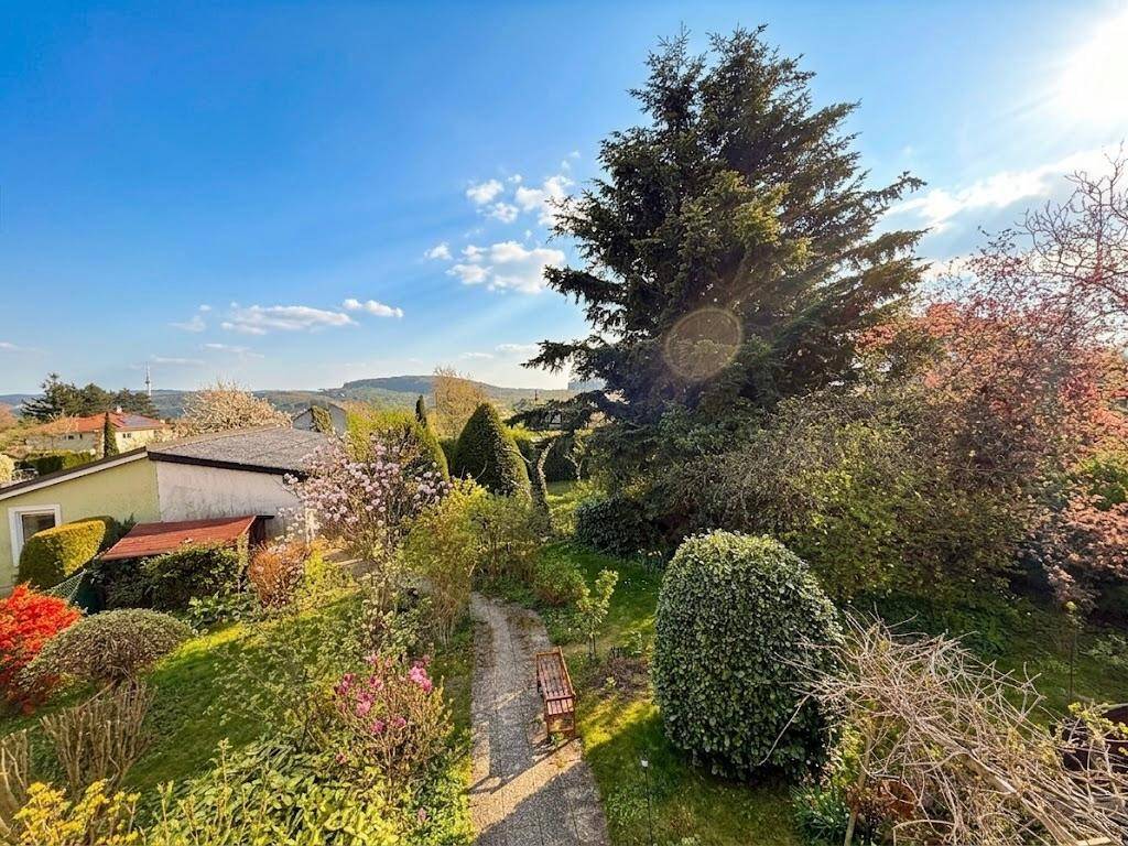 Weitläufiger Garten mit vielfältiger Bepflanzung und Panoramablick in die Landschaft.