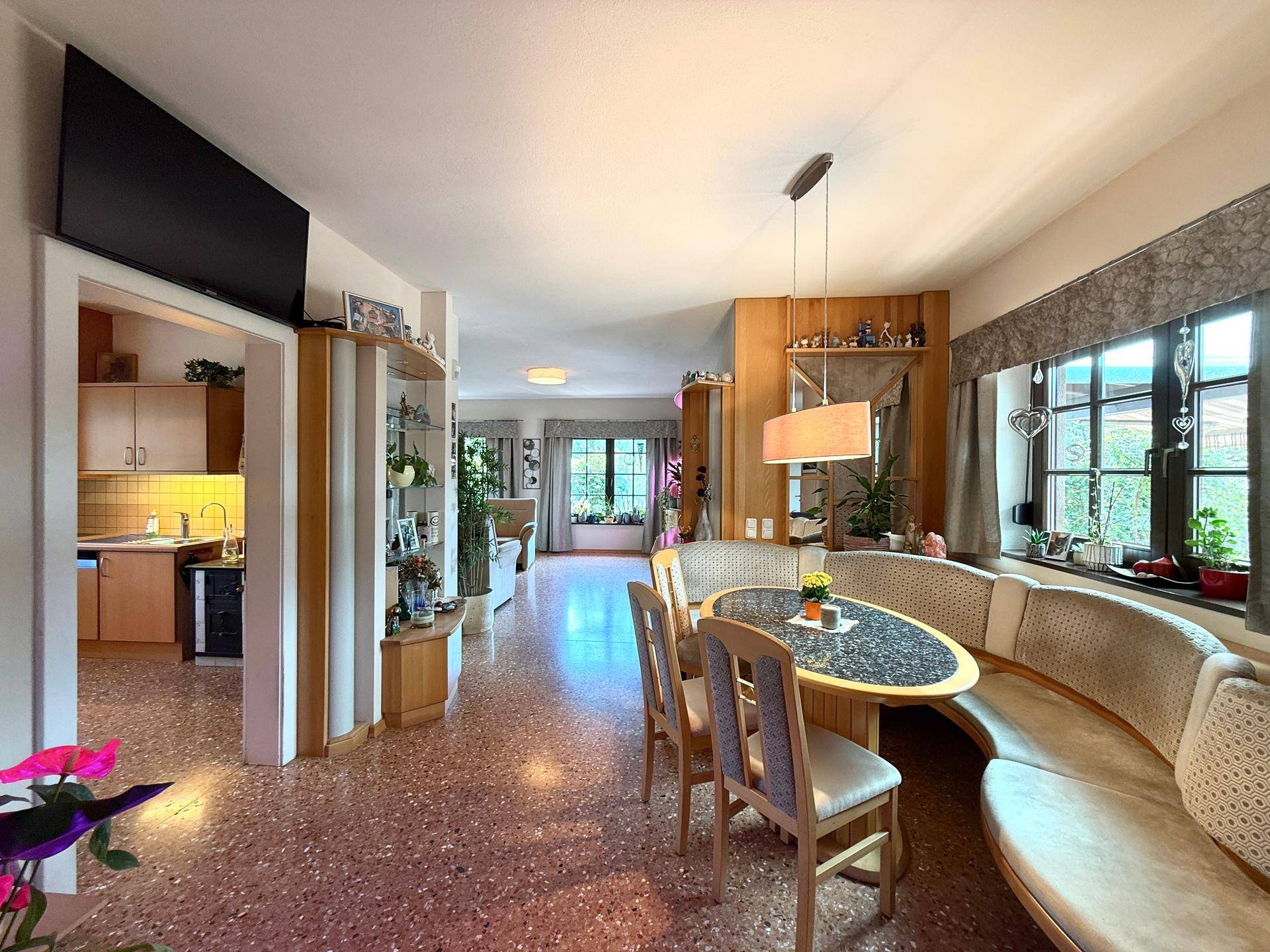 Gemütlicher Essbereich mit runder Sitzbank und Blick in die angrenzende Küche und das Wohnzimmer.