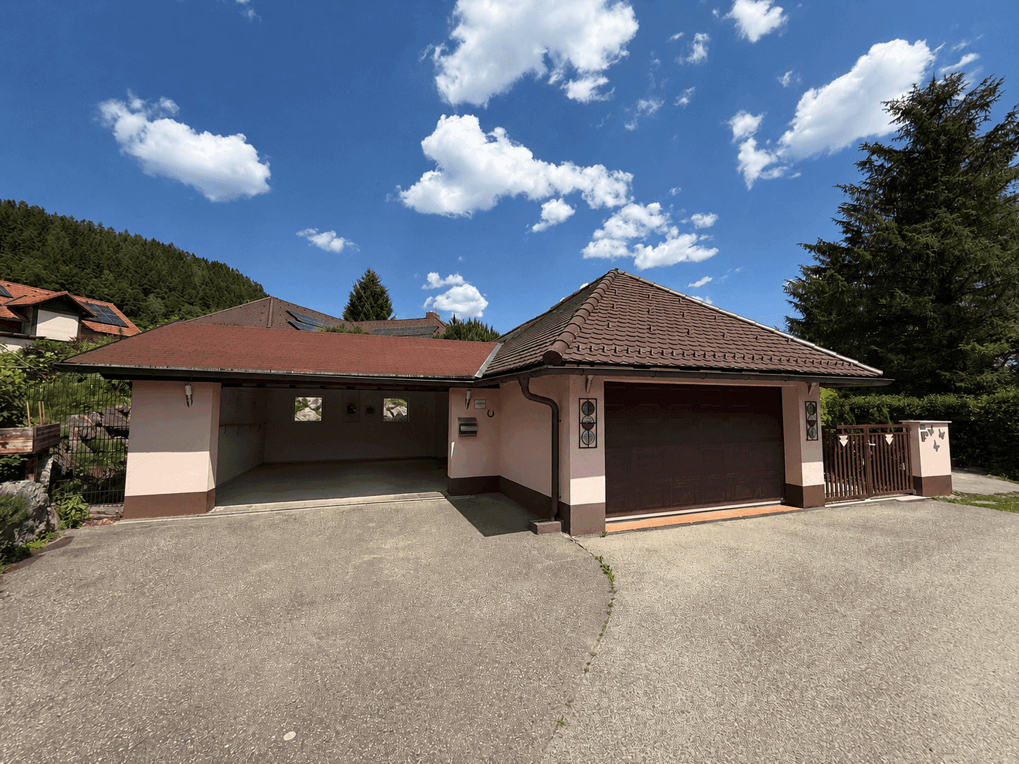 Doppelgarage und Carport mit Zufahrt, Teil eines charmanten Hauses in ländlicher Umgebung.