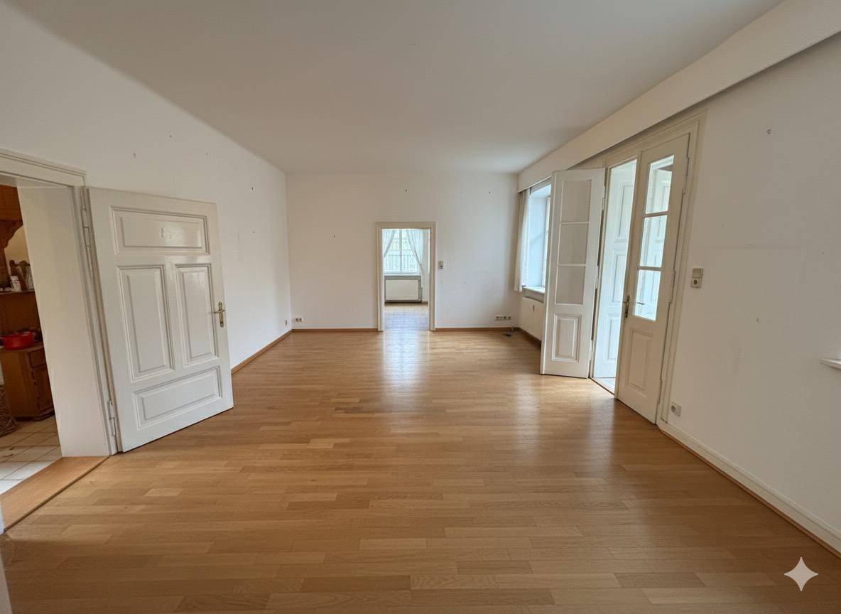 Helles, leeres Zimmer mit Holzboden und weißen Wänden, bereit zur individuellen Gestaltung.