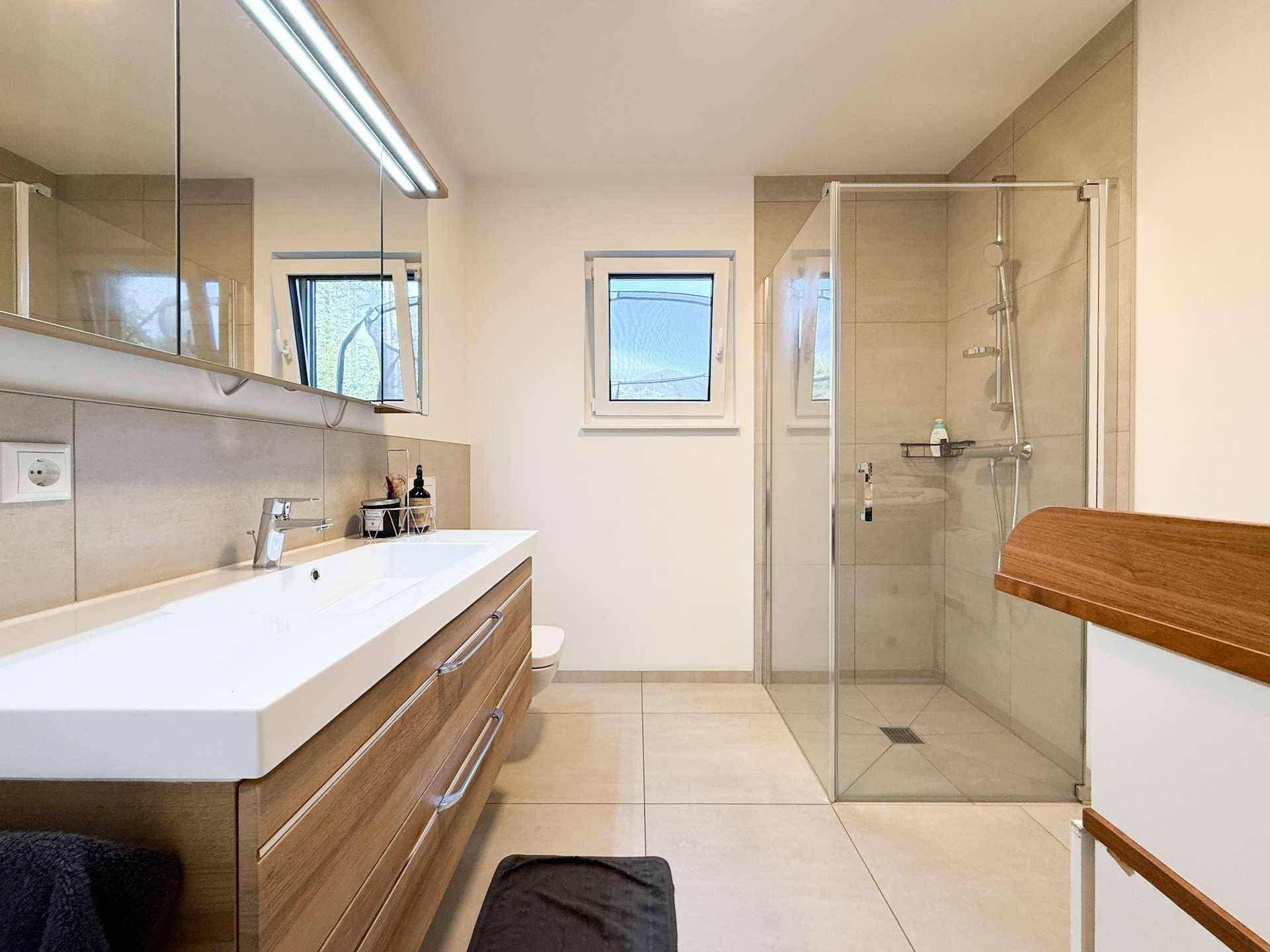 Modernes Badezimmer mit großer Dusche, Einzelwaschbecken und Fenster.