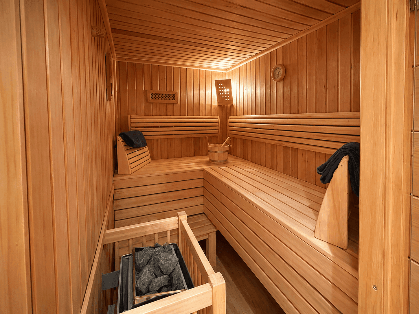 Geräumige Holzsauna mit mehreren Bänken und Saunaofen, ideal zur Entspannung nach einem Skitag.