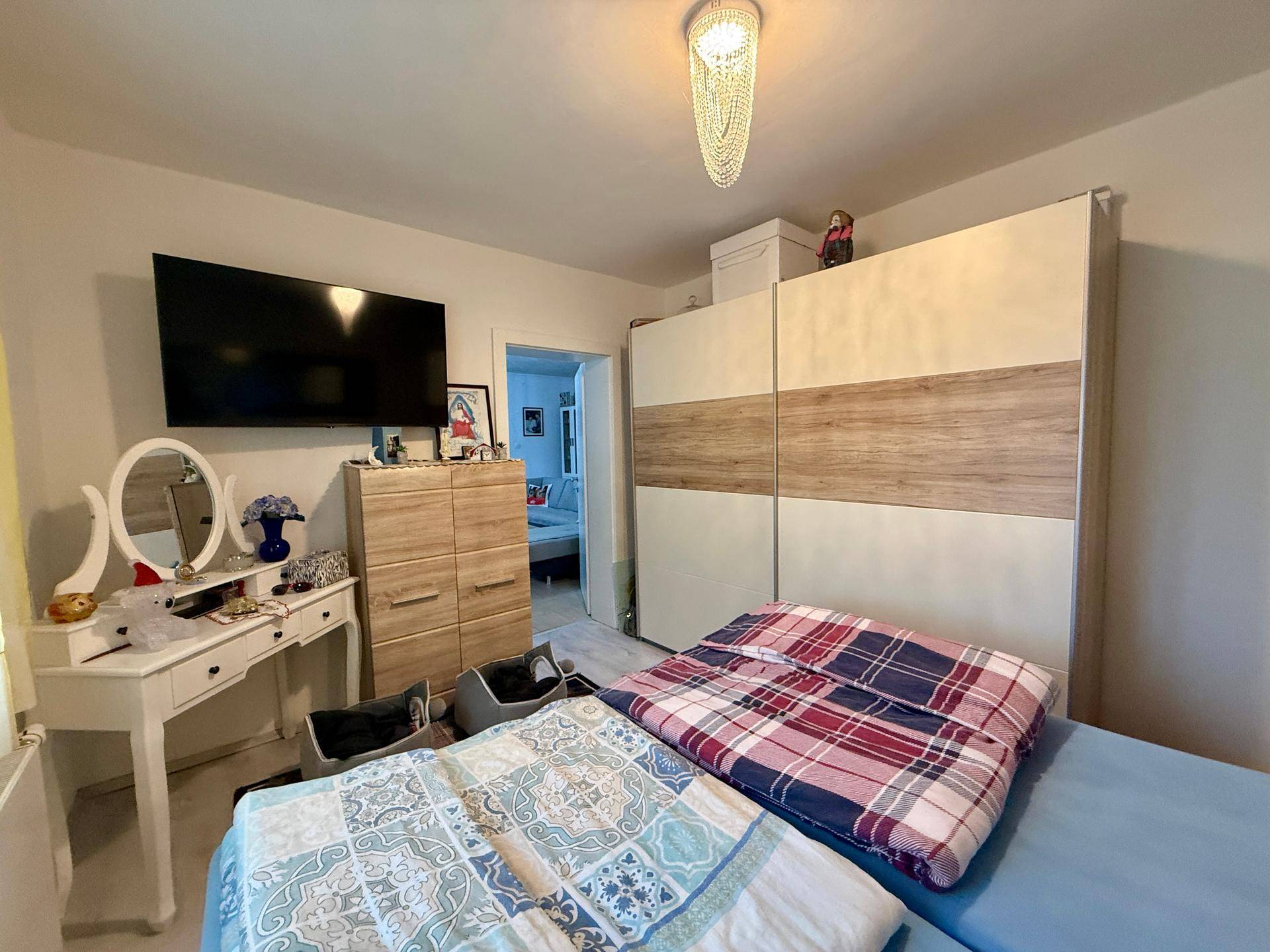 Schlafzimmer mit großem Kleiderschrank, Schminktisch und Doppelbett.
