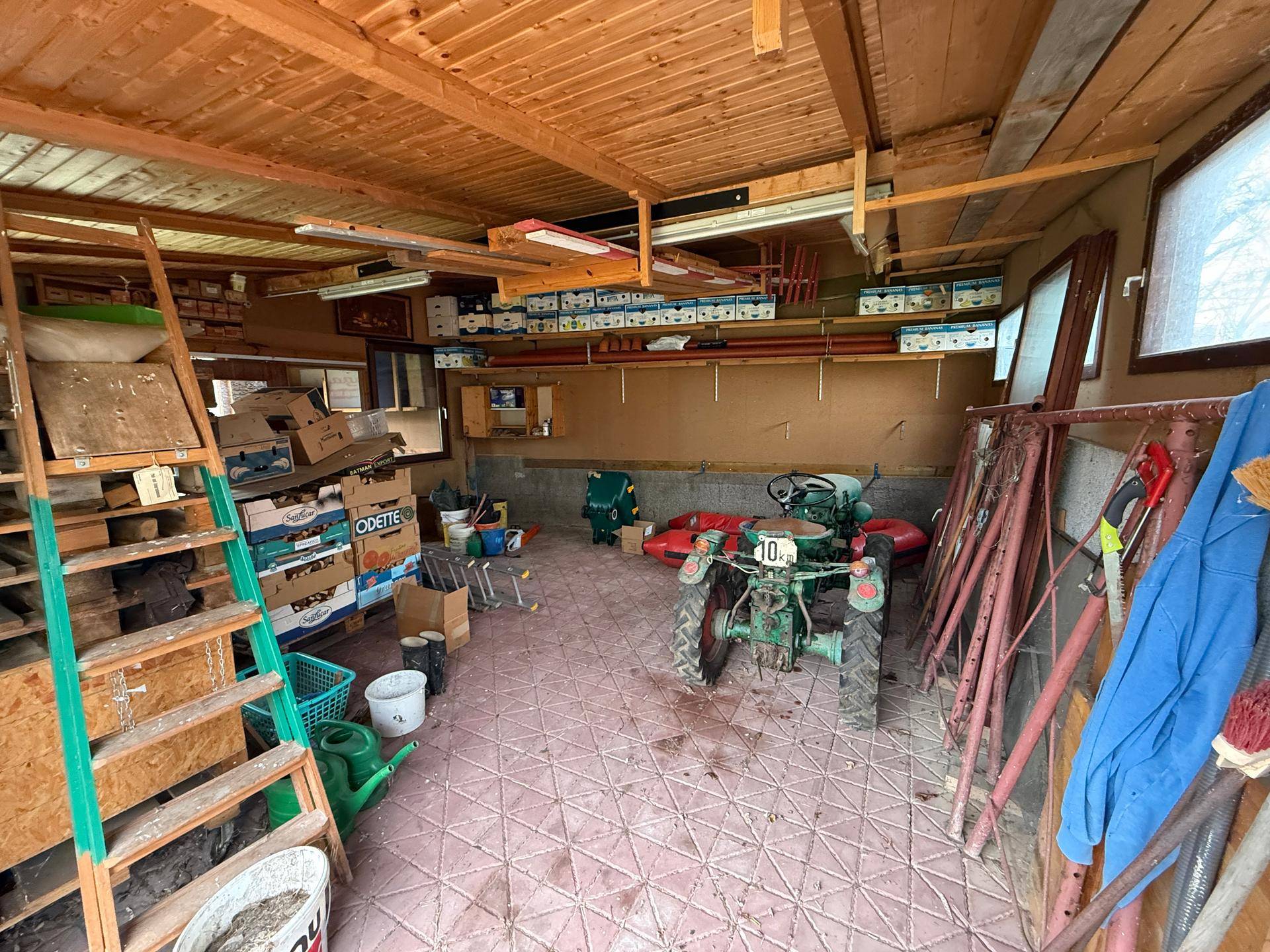 Geräumiger Geräteschuppen mit Holzdecke und Fliesenboden, ideal für Gartengeräte.