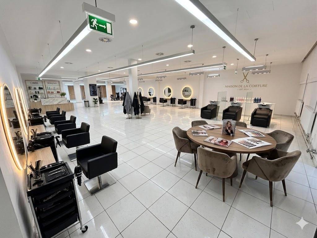 Modern eingerichteter Friseursalon mit zahlreichen Bedienplätzen, bequemen Stühlen und runden Spiegeln.