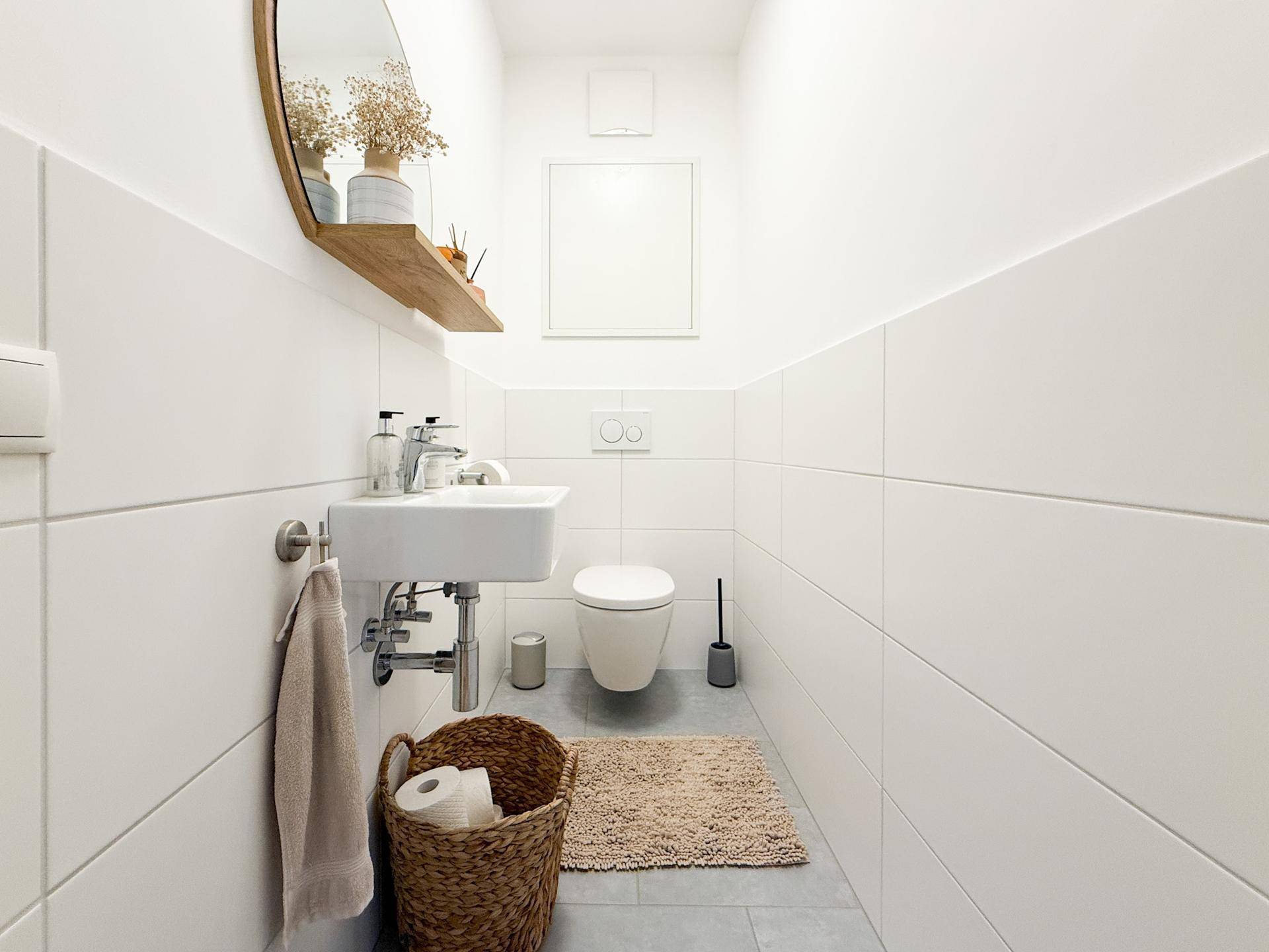 Kleines, helles Gäste-WC mit modernem Waschbecken und Wandtoilette.