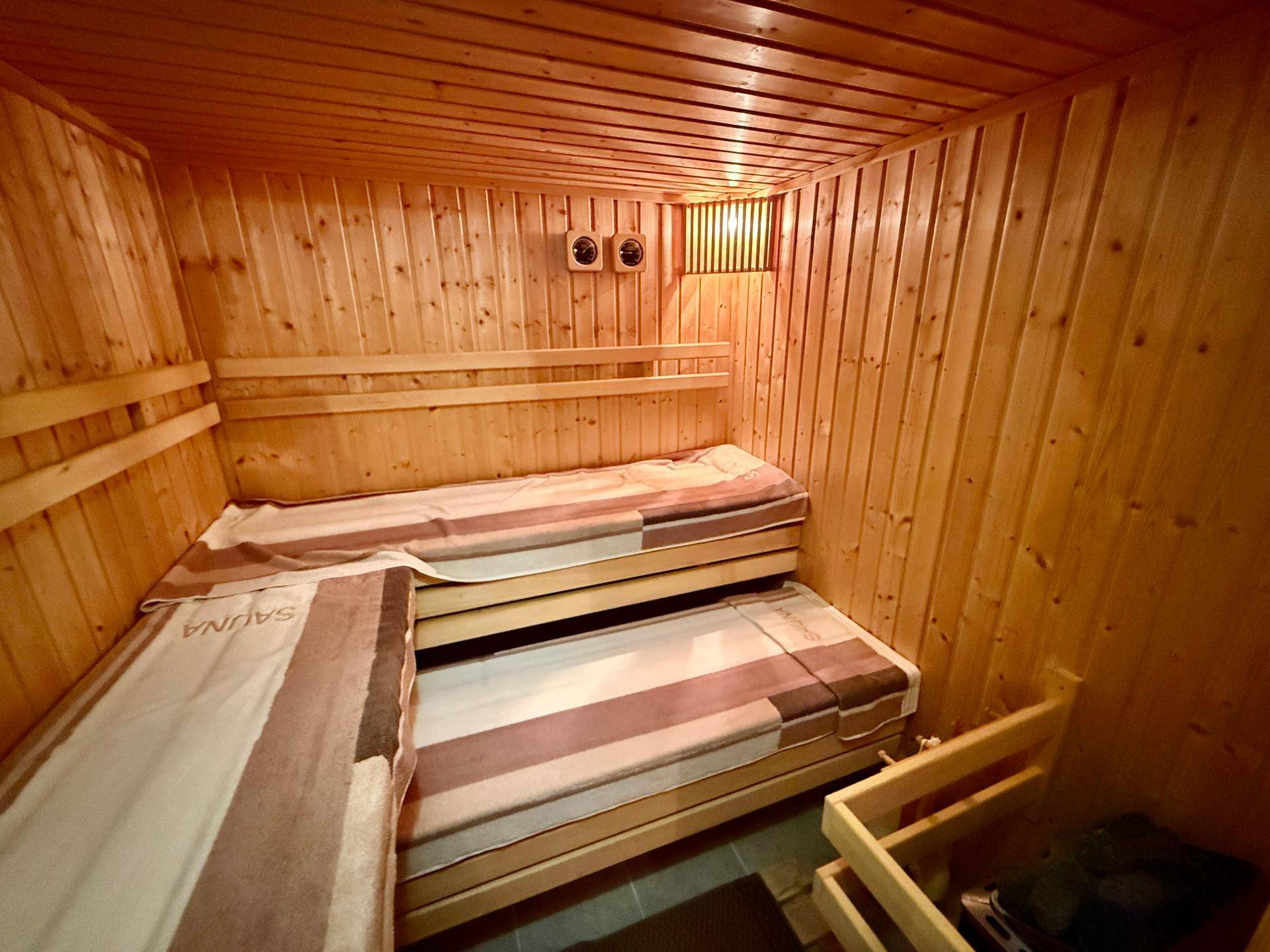 Holzvertäfelte Sauna mit zwei Liegeebenen für Entspannung und Wellness.