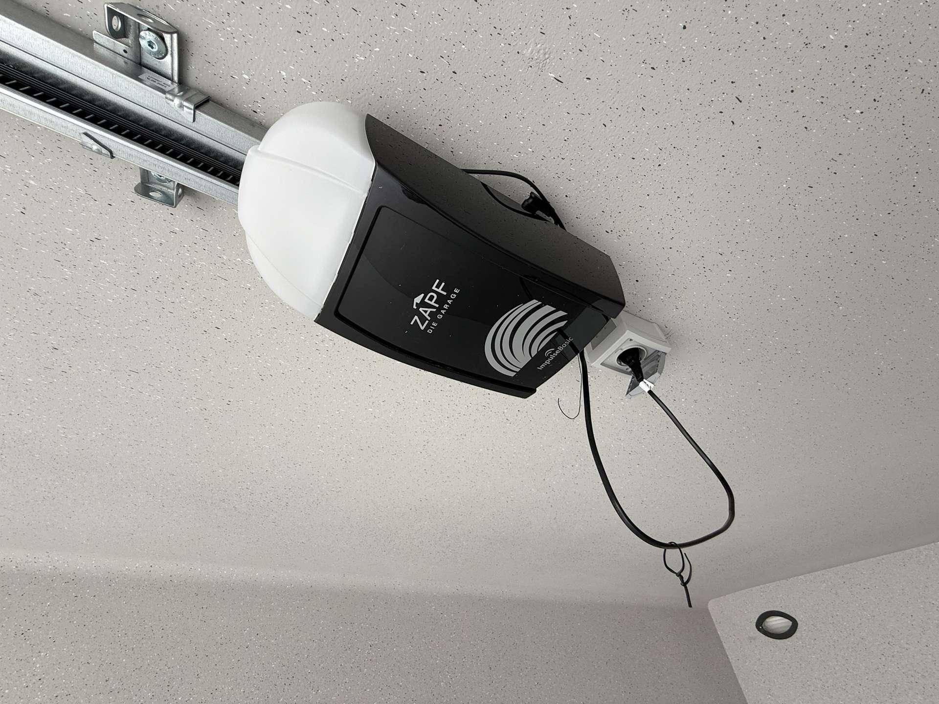 Detailansicht eines automatischen Garagentoröffners, der an der Decke der Garage montiert ist.