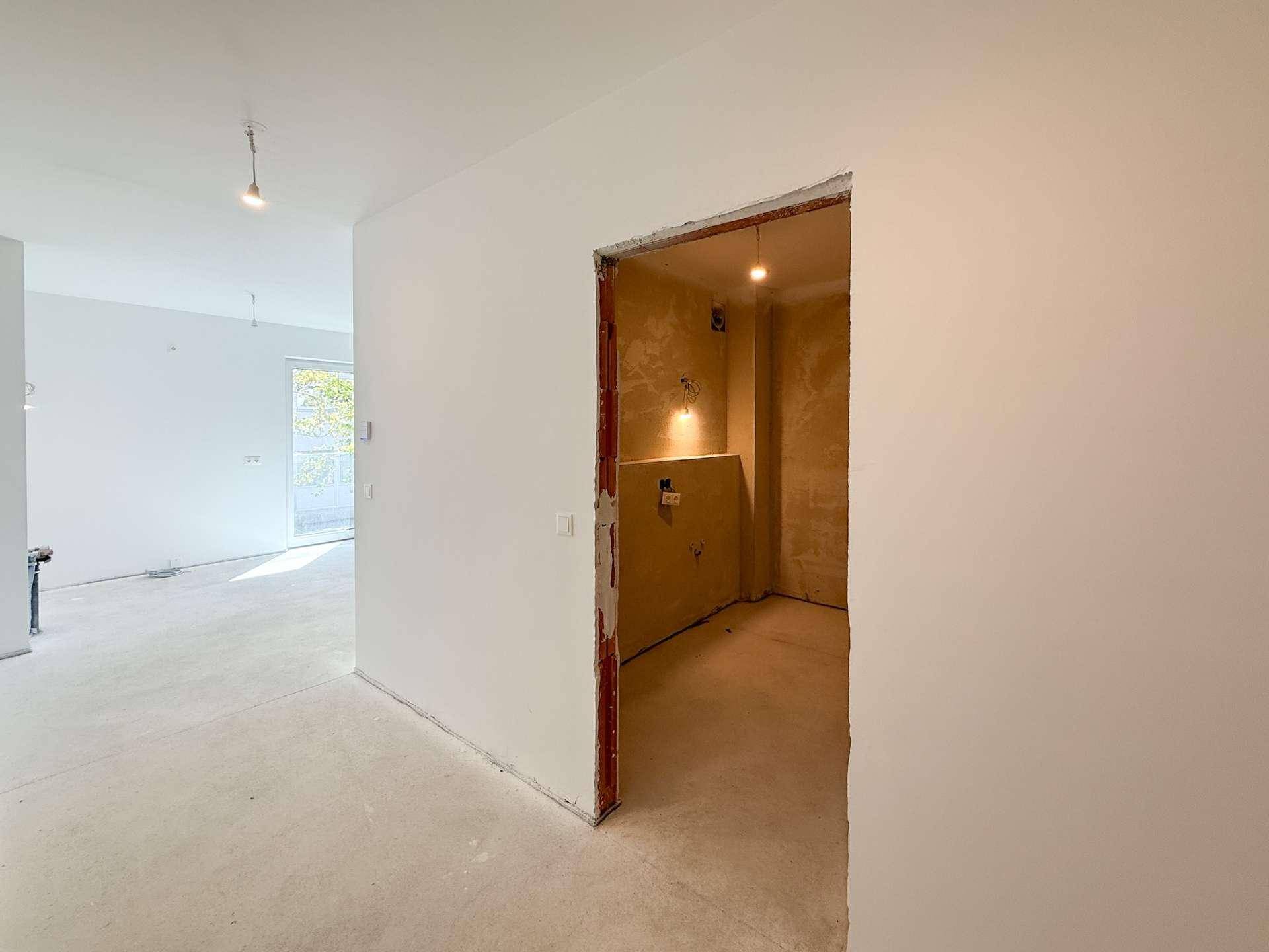 Unfertiger Raum mit sichtbaren Sanitärinstallationen, bereit für den Ausbau zum Badezimmer.