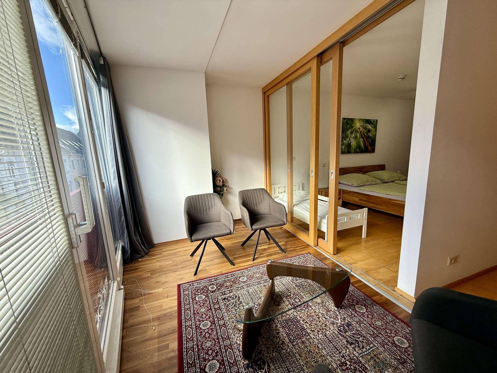 Helle Loggia mit großen Fenstern, die viel Tageslicht hereinlassen und einen Ausblick bieten.