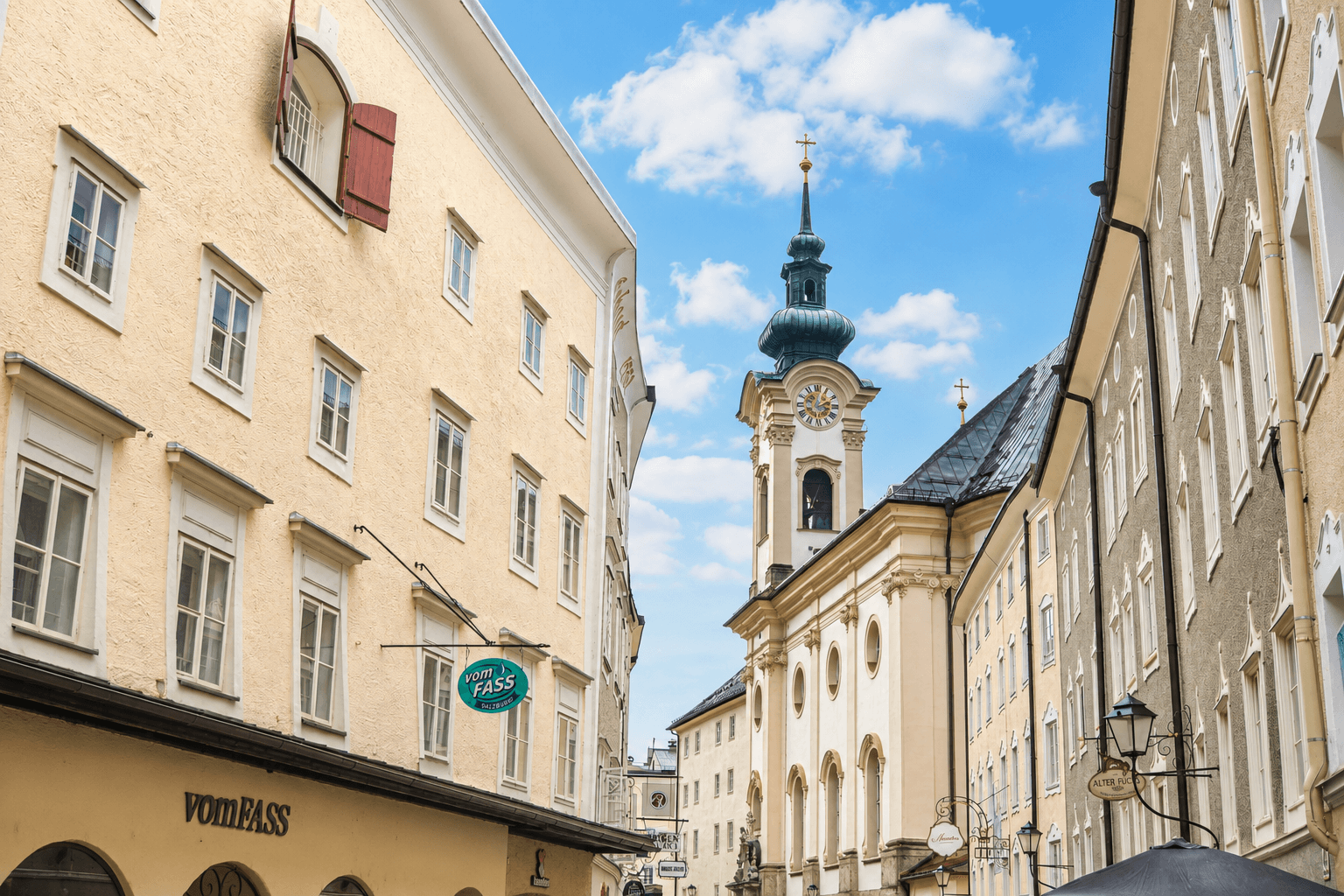 Historische Gasse mit charmanten Altbauten und einem markanten Kirchturm.