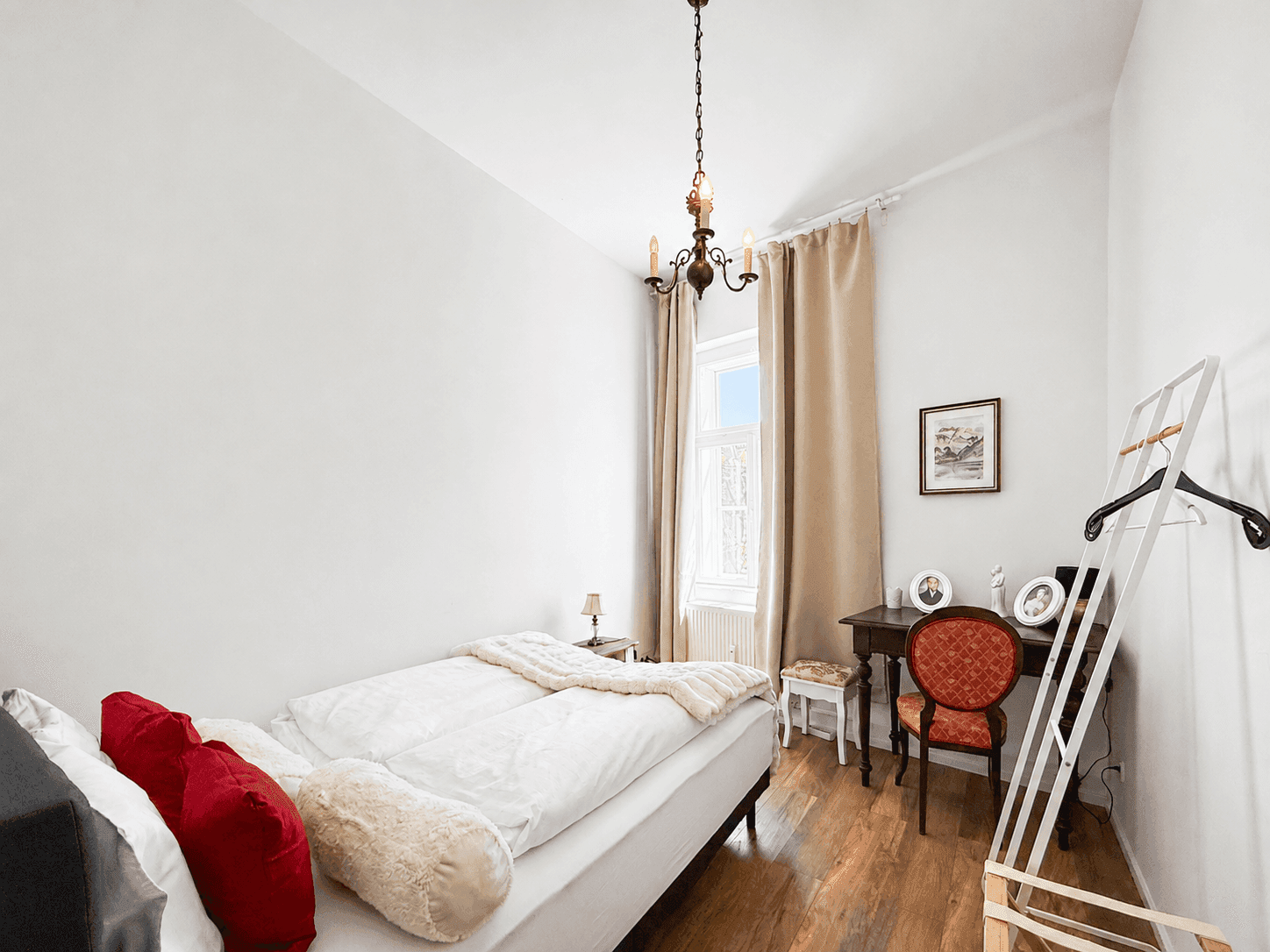 Helles Schlafzimmer mit Einzelbetten, Holzboden und Schreibtisch am Fenster.