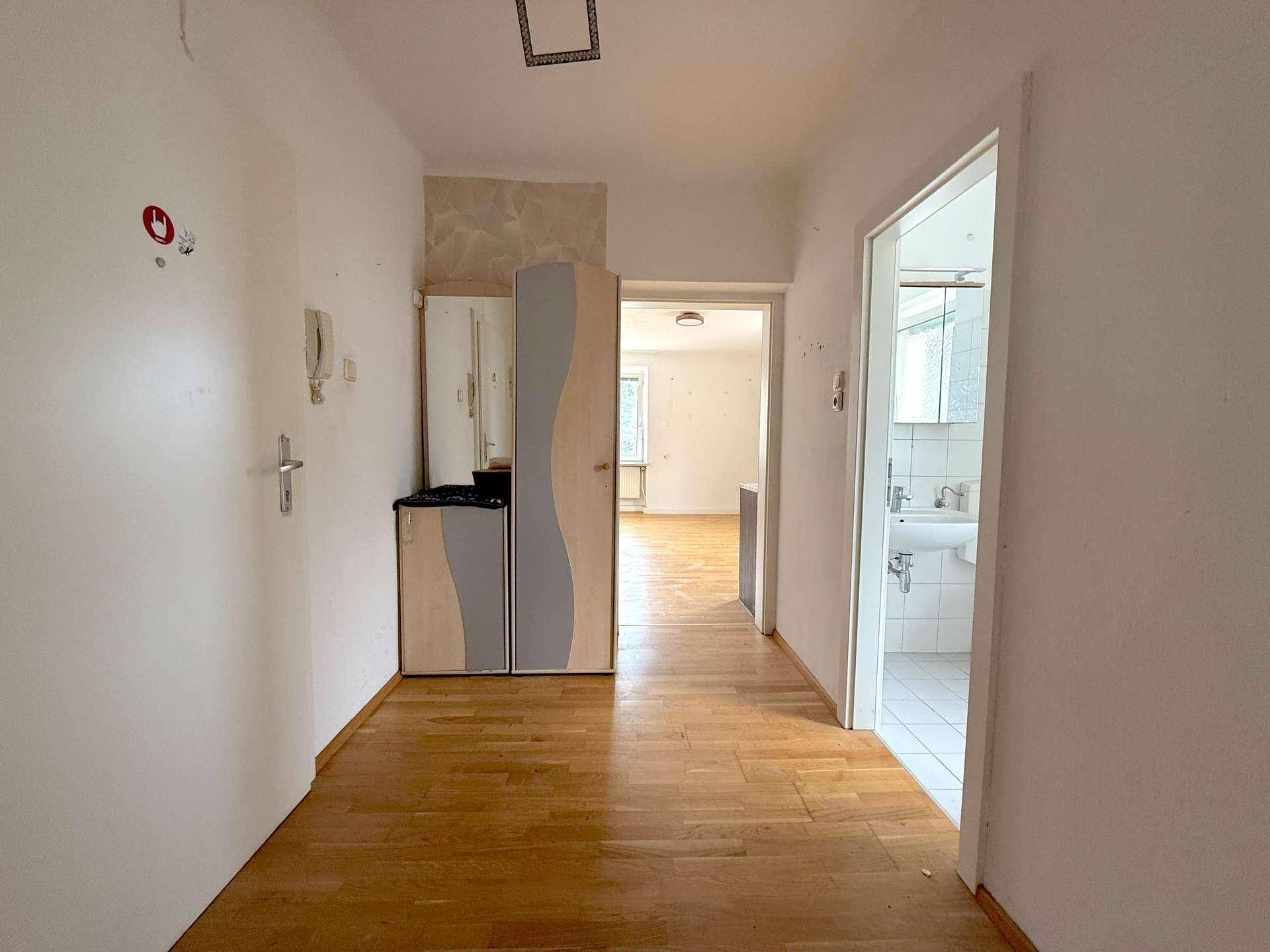 Heller Flur mit Parkettboden, Garderobe und Zugang zu weiteren Räumen.