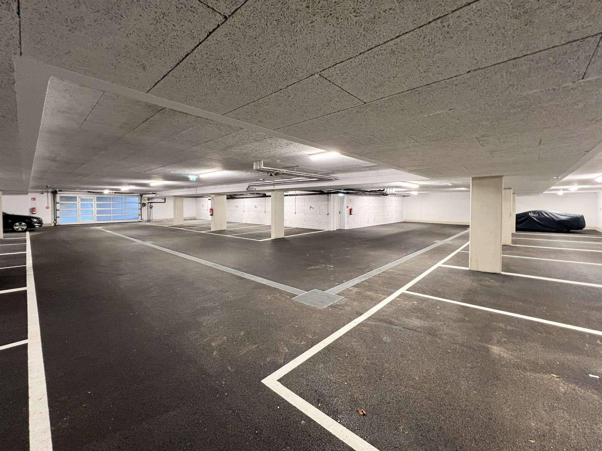 Geräumige Tiefgarage mit markierten Stellplätzen und guter Beleuchtung.