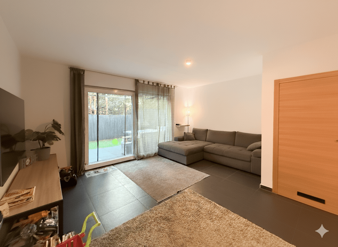 Helles Wohnzimmer mit großem Ecksofa, Fernseher und direktem Zugang zum Garten.