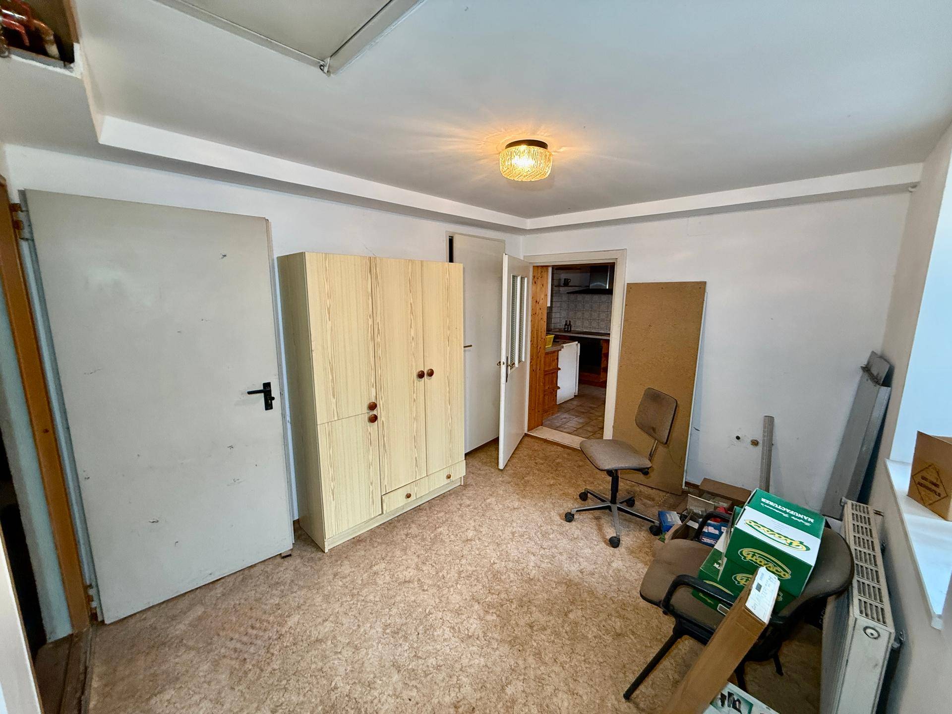 Kleiner Raum mit Schrank und Heizkörper, derzeit als Abstellraum genutzt.