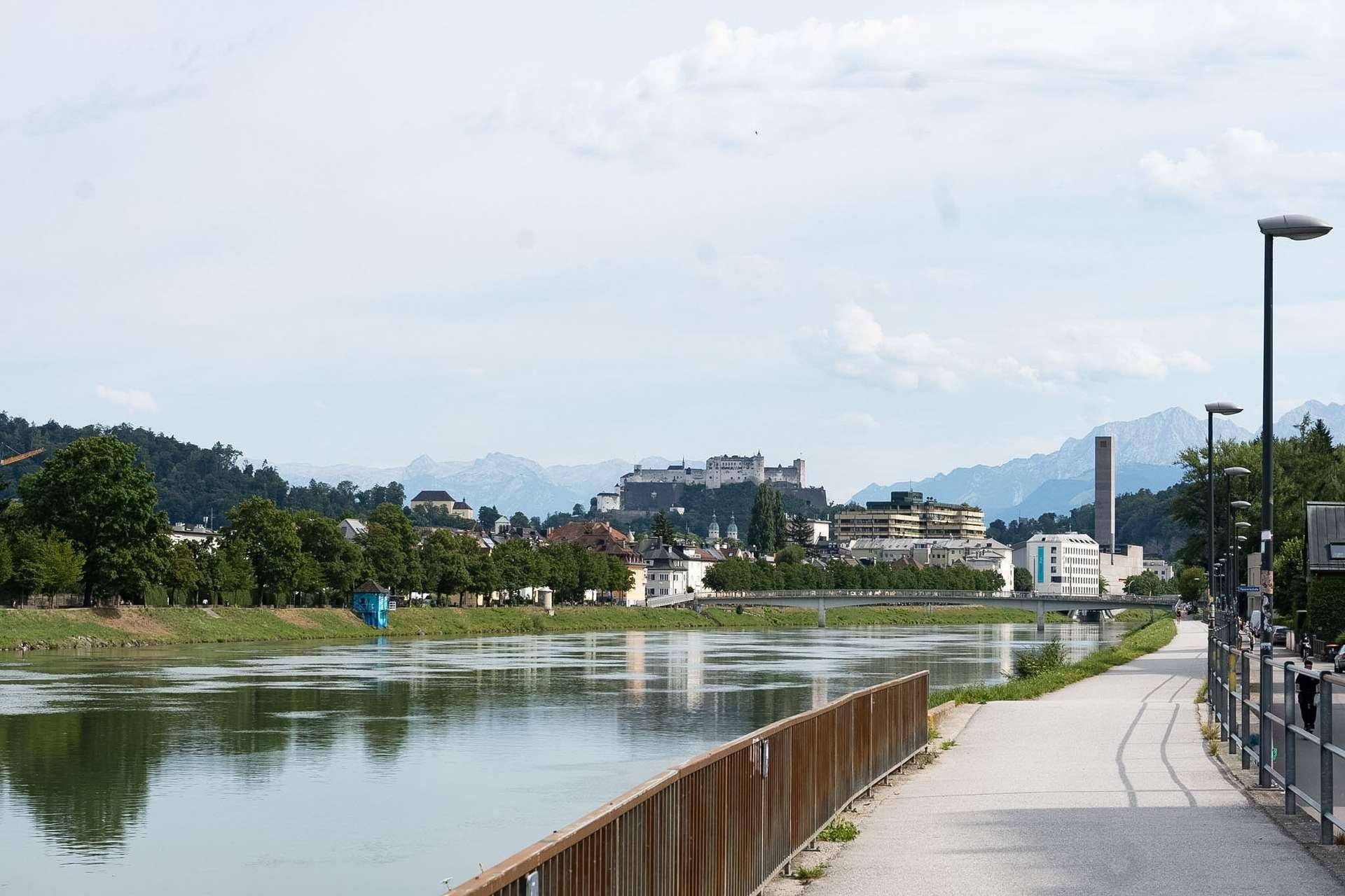 Malerischer Blick auf den Fluss, die Stadt und die umliegende Berglandschaft.
