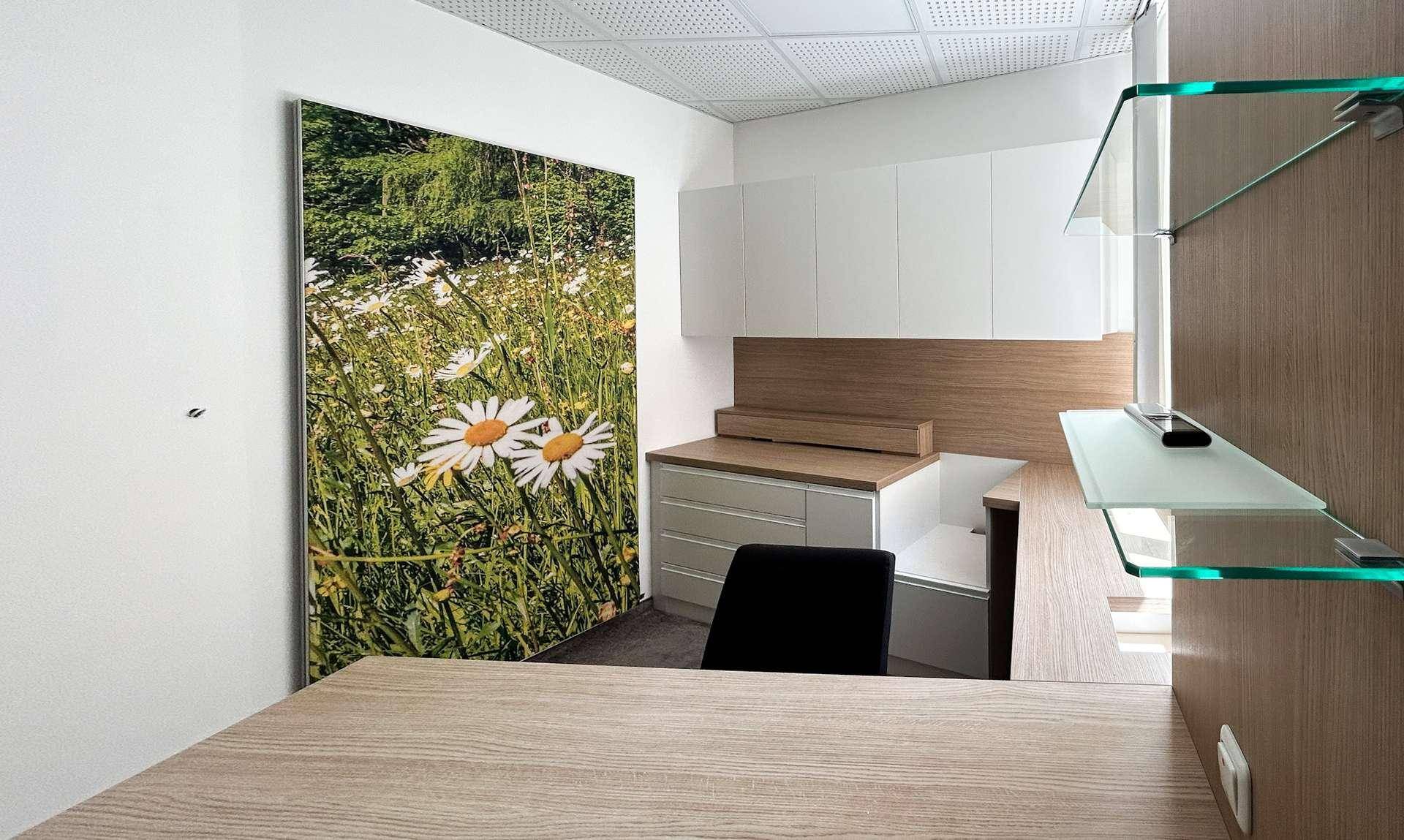 Modernes Büro mit Holzmöbeln, Glasregalen und einem großen Wandbild.
