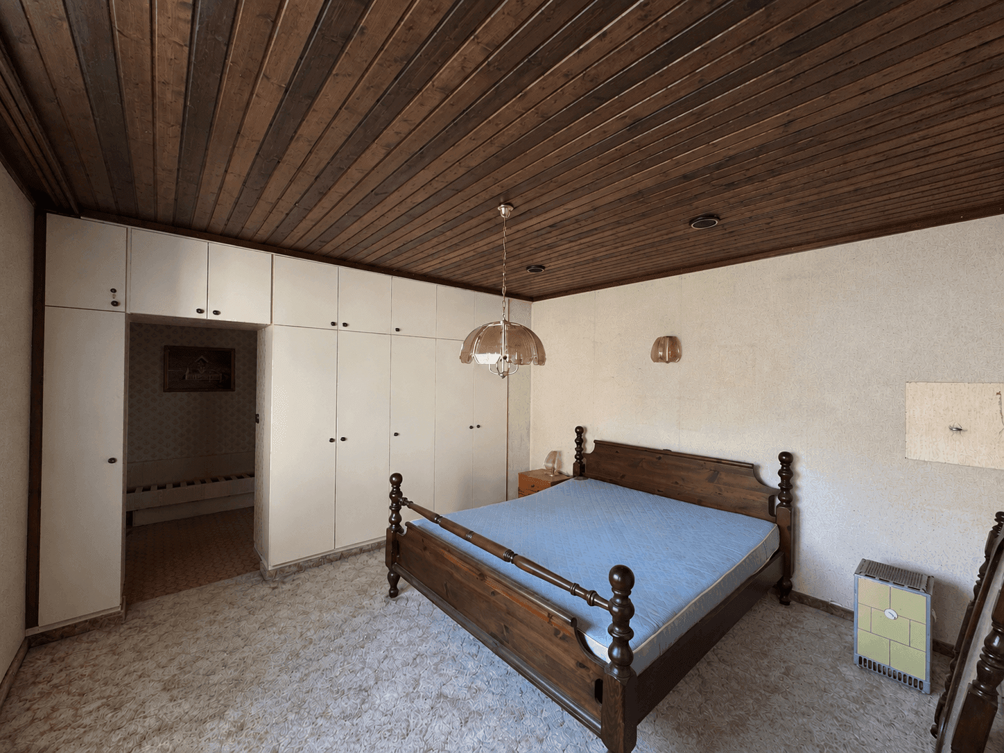 Schlafzimmer mit Doppelbett, Einbauschränken und Teppichboden.