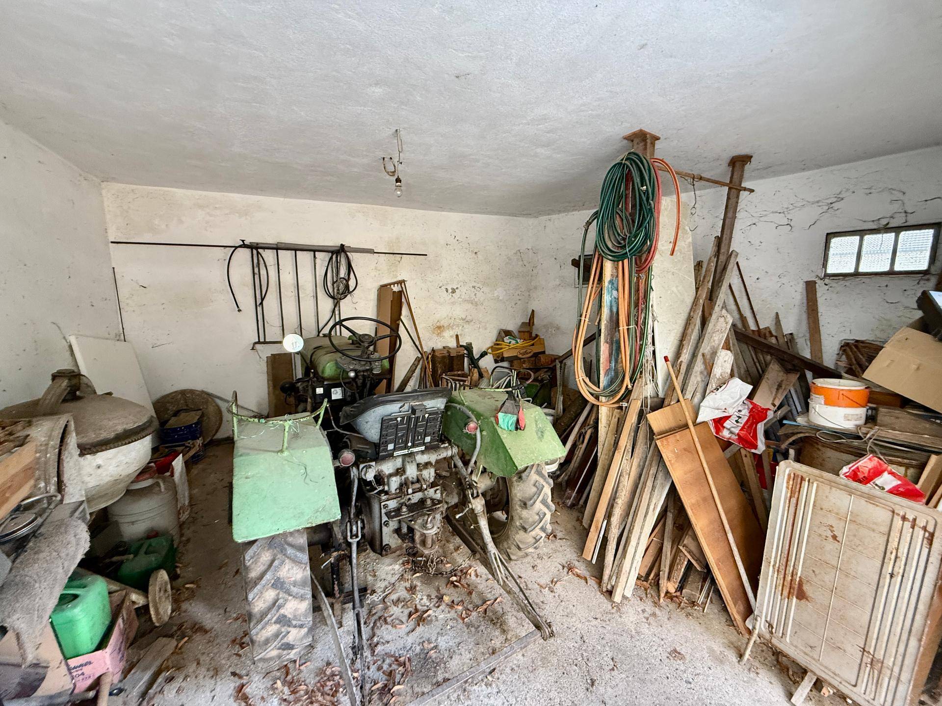 Geräumige Garage oder Scheune mit einem Traktor und Lagerflächen.